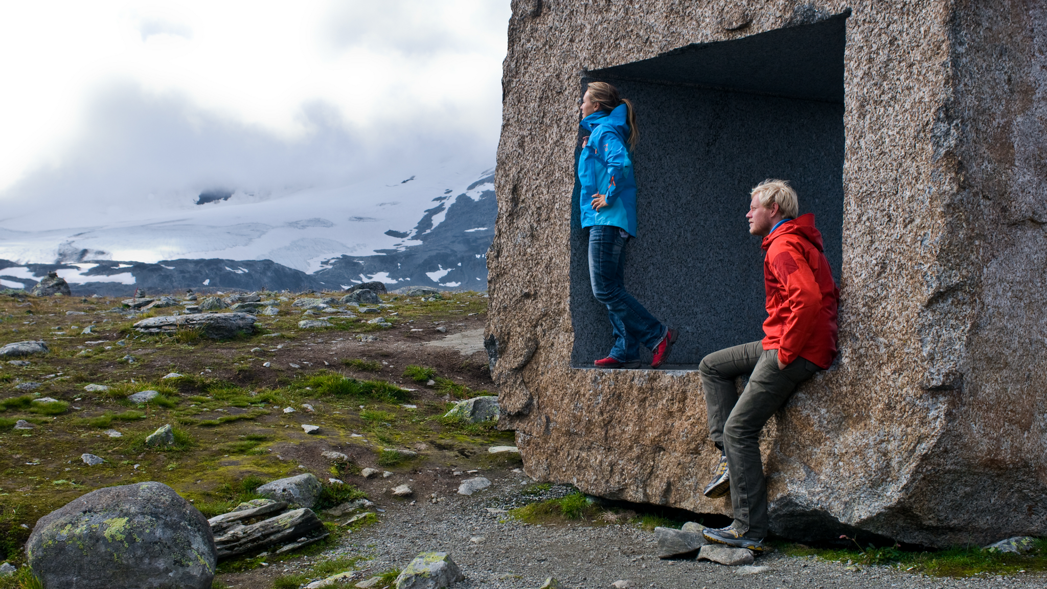 Two people posing at the Mefjellet stone scuplture
