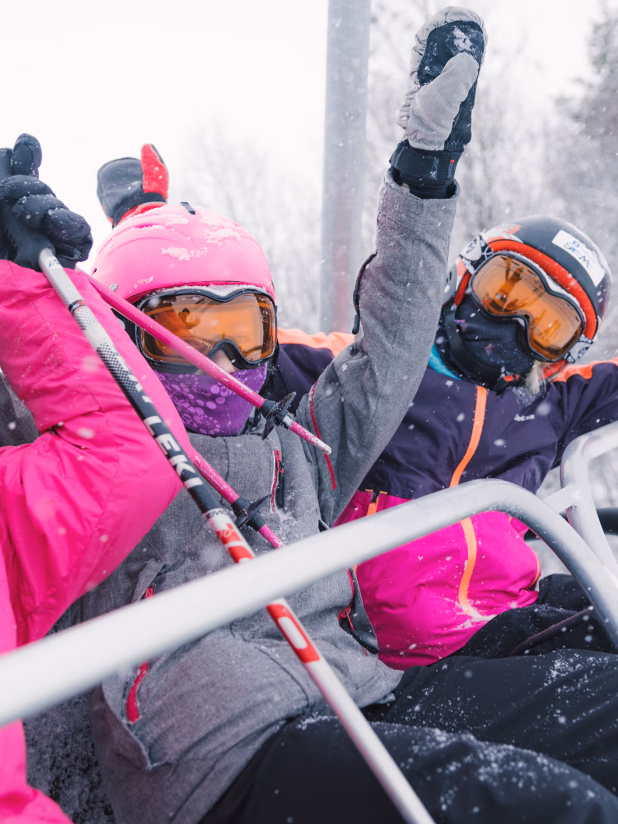 Three happy girls sitting in a ski lift in Geilo ski resort, Eastern Norway