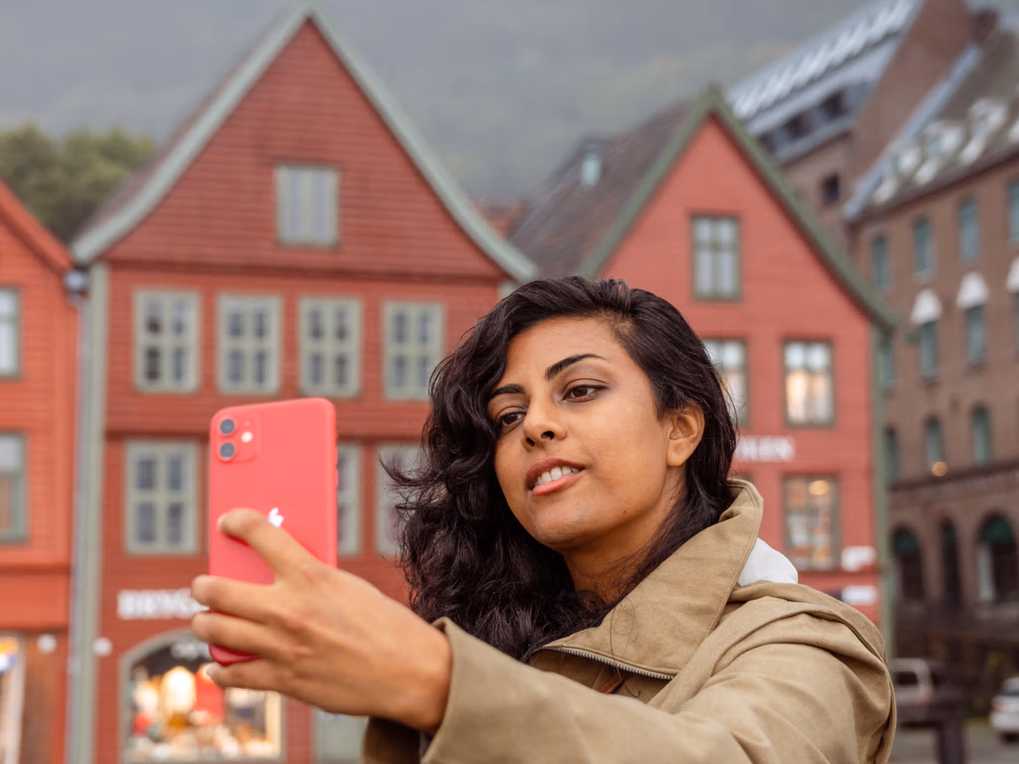 A woman on a walking tour taking a selfie at Bryggen in Bergen, Fjord Norway