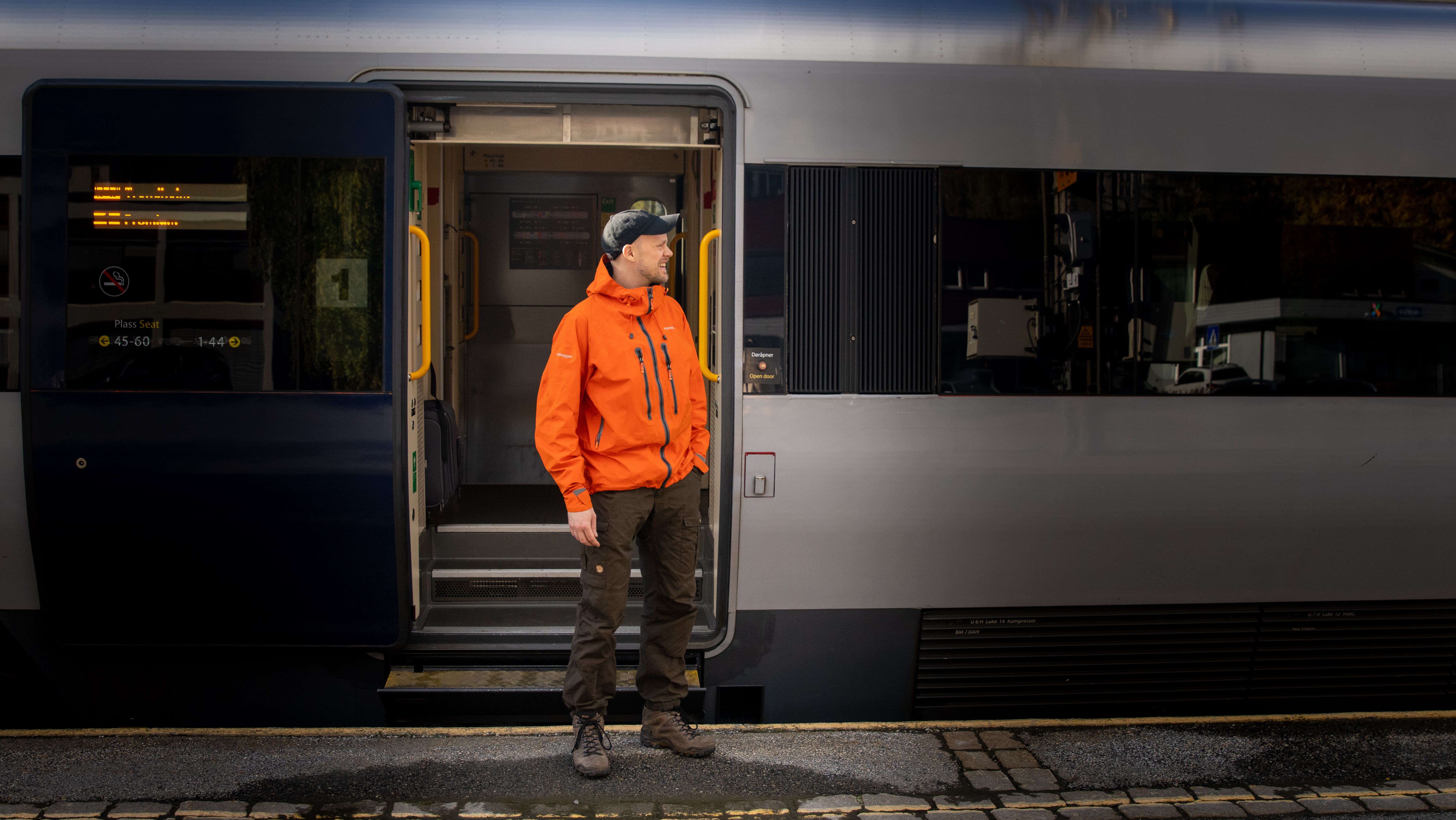 A man getting on board on the Dovre Railway train.
