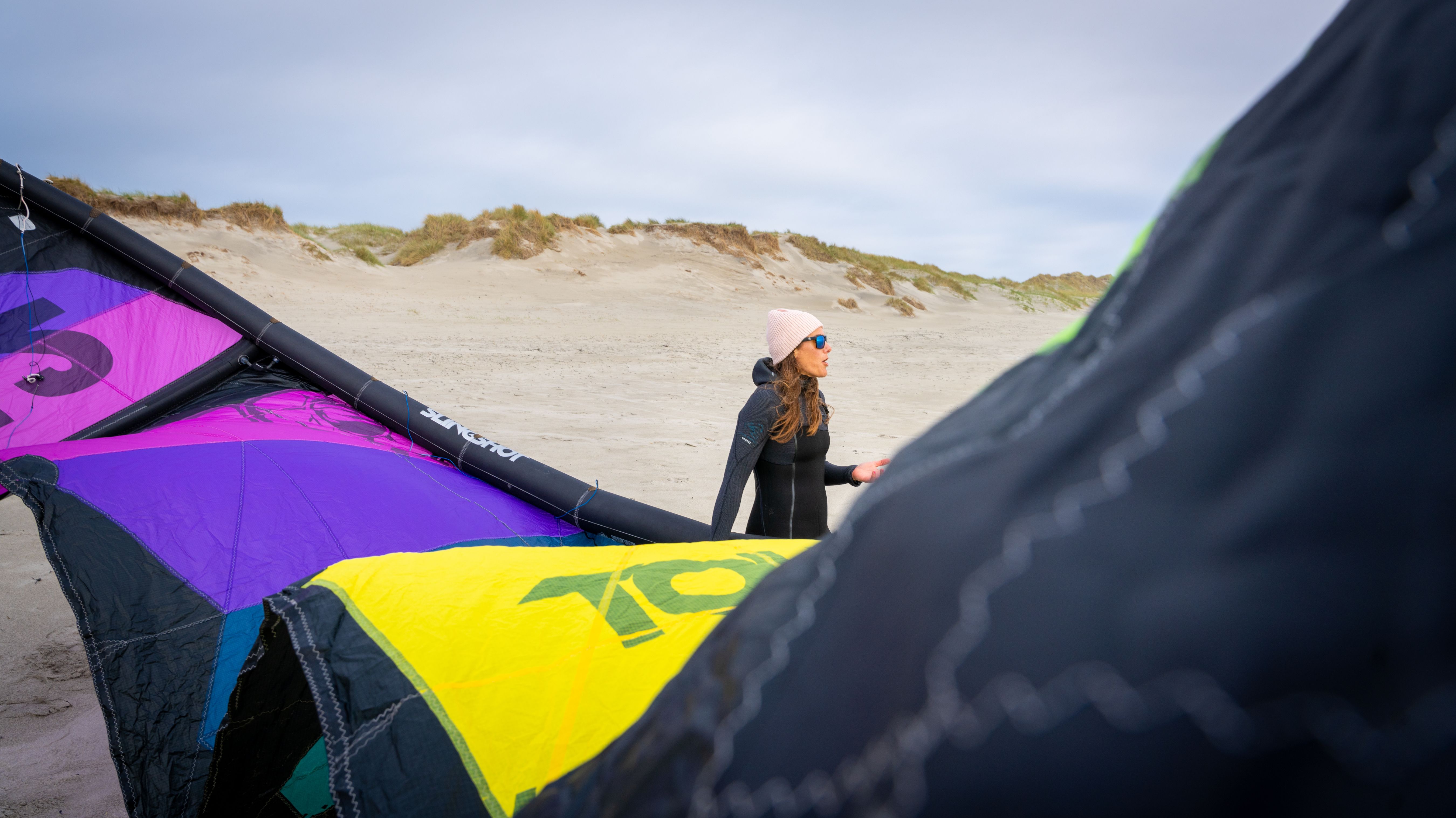 A woman with kiting equipment at a beach outside of Stavanger, Fjord Norway.
