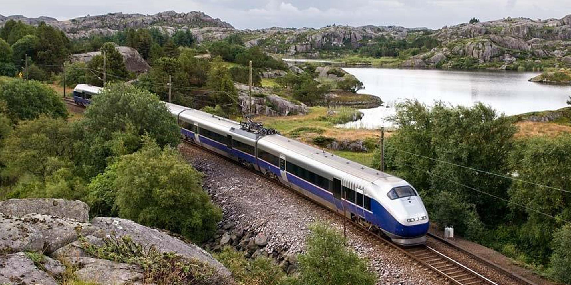 Et tog kjører forbi en innsjø på Jærbanen
