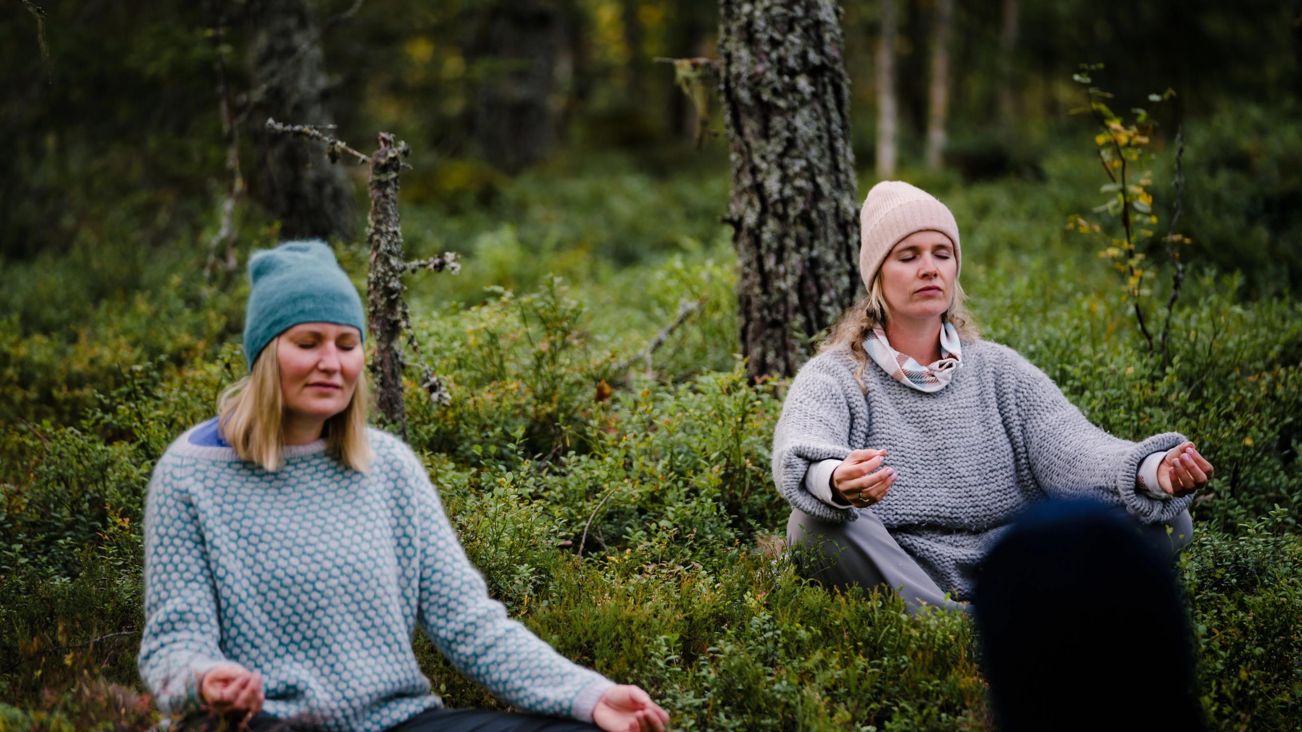 Twee vrouwen mediteren in het Finnskogen-bos in de provincie Hedmark