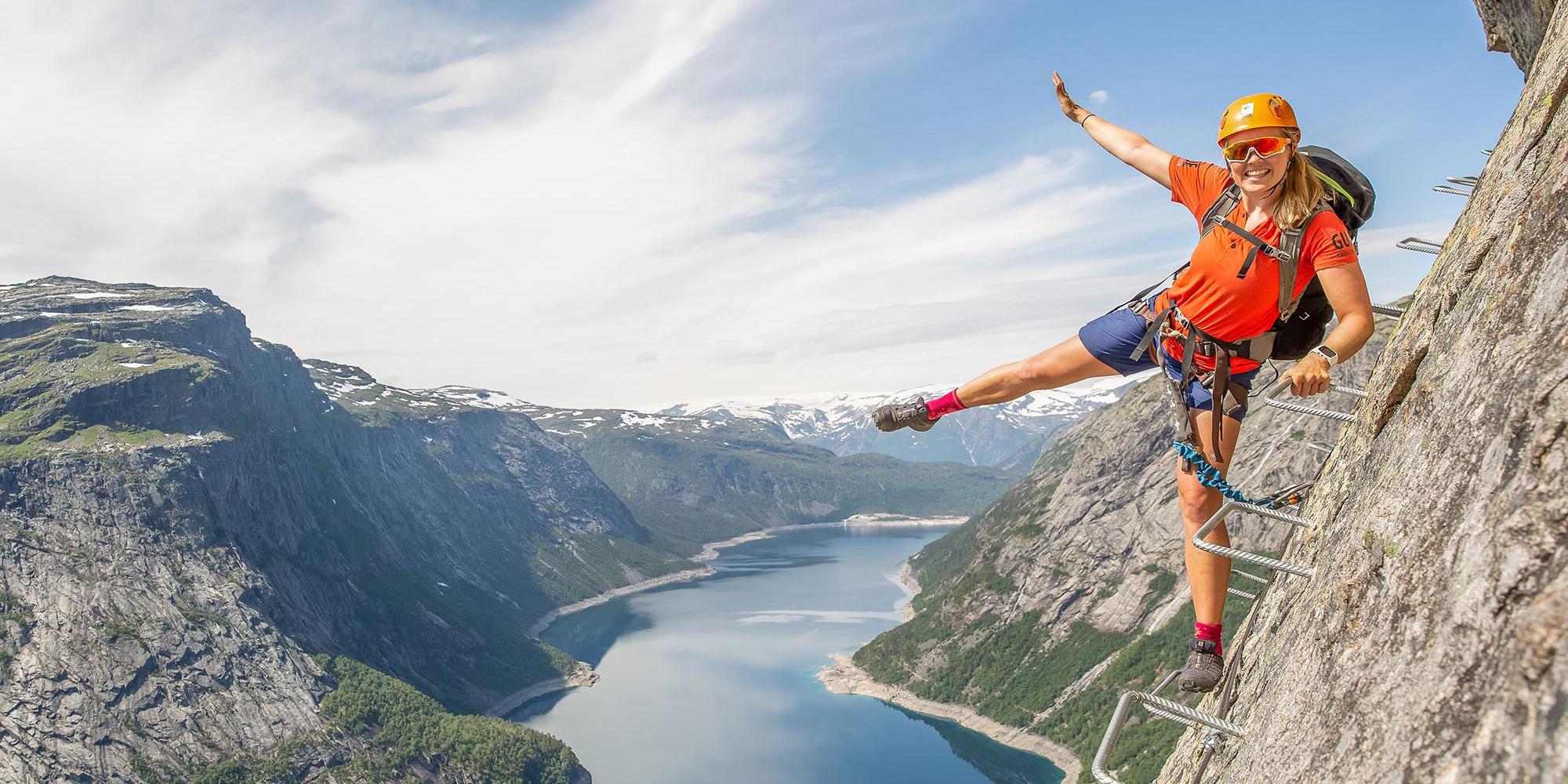Active holiday in Norway: Woman climbing the Trolltunga via ferrata in Fjord Norway