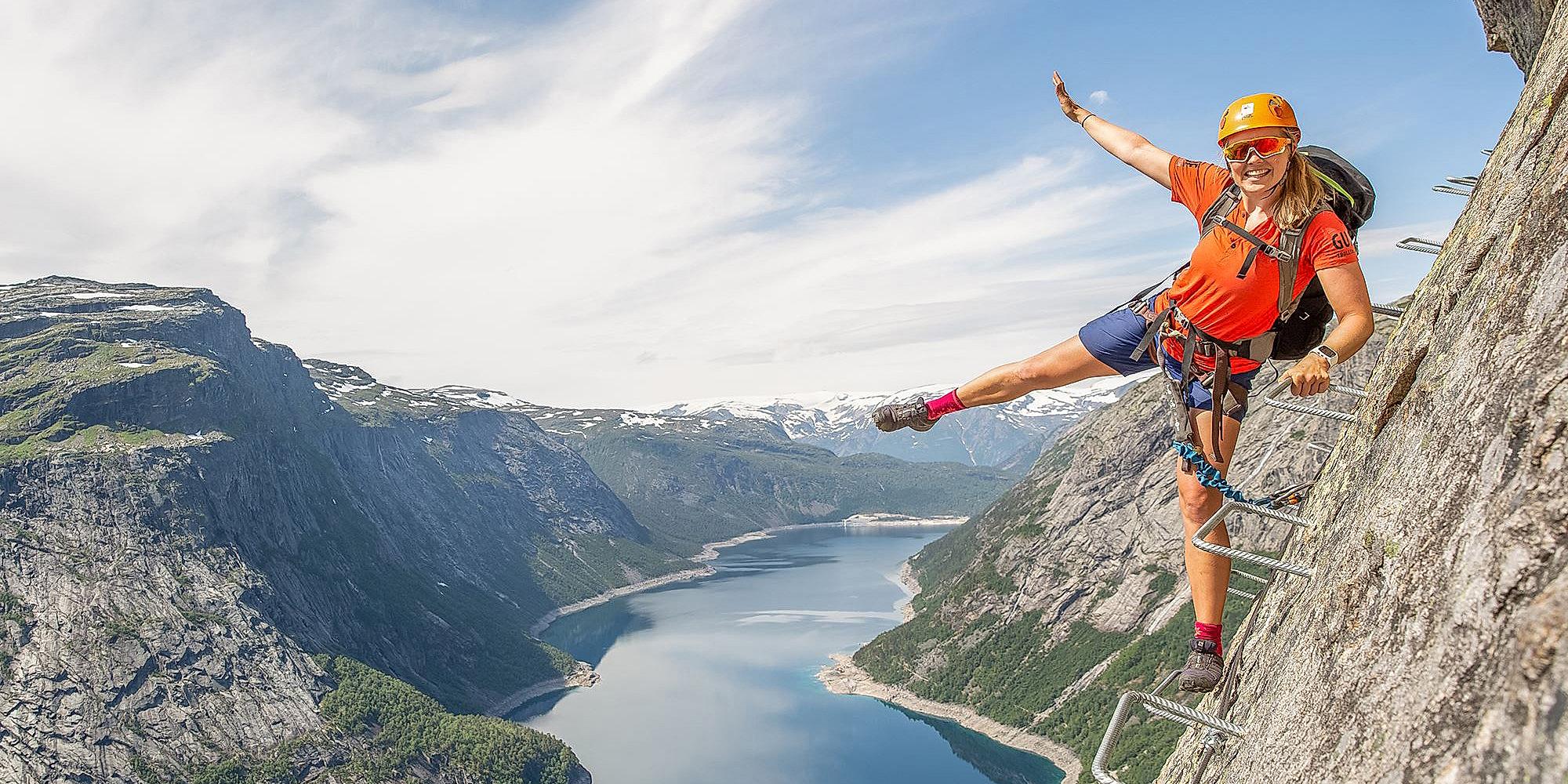 Active holiday in Norway: Woman climbing the Trolltunga via ferrata in Fjord Norway