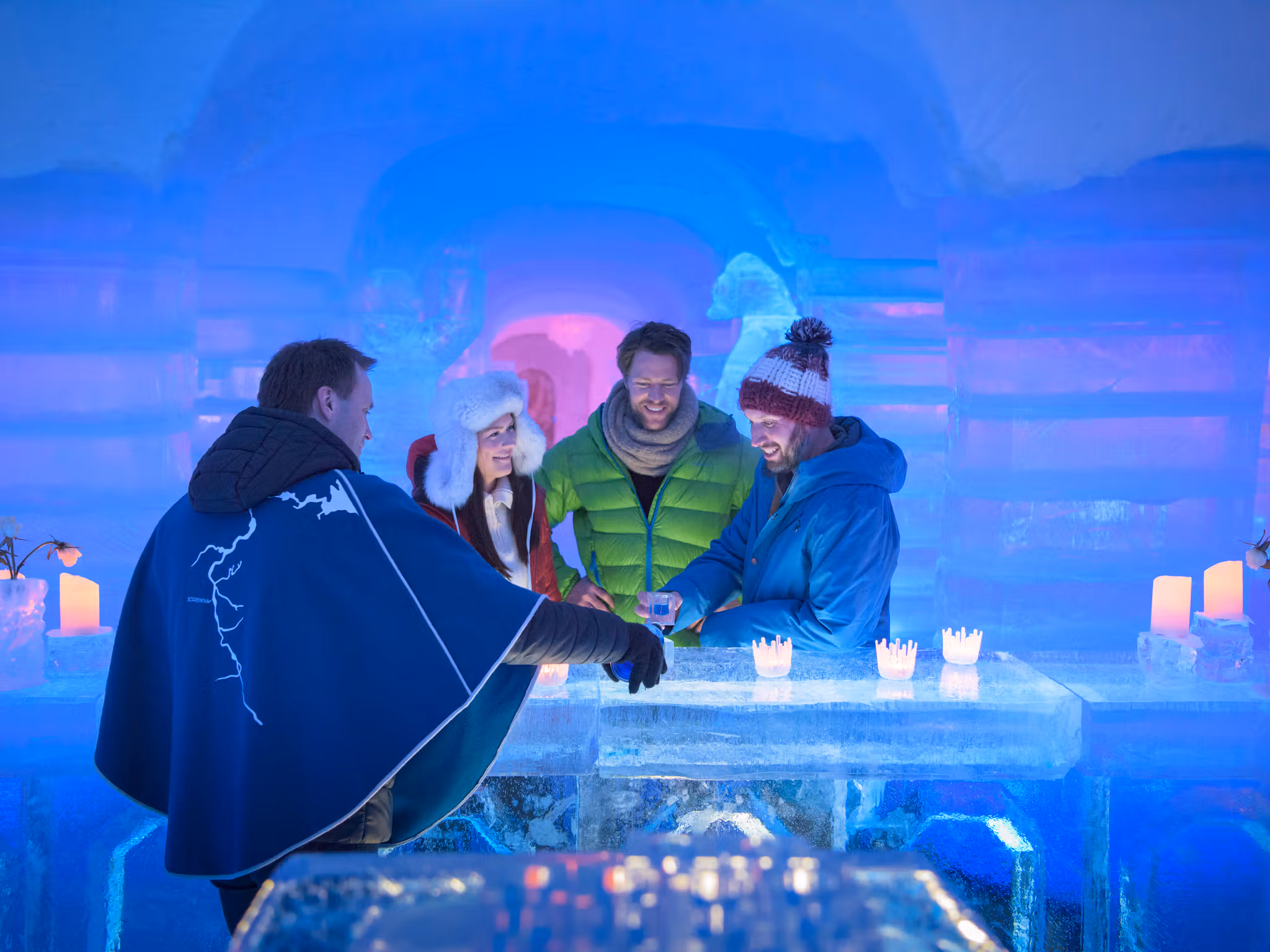 Four persons having a drink at the bar of the Sorrisniva Igloo Hotel in Alta, Northern Norway