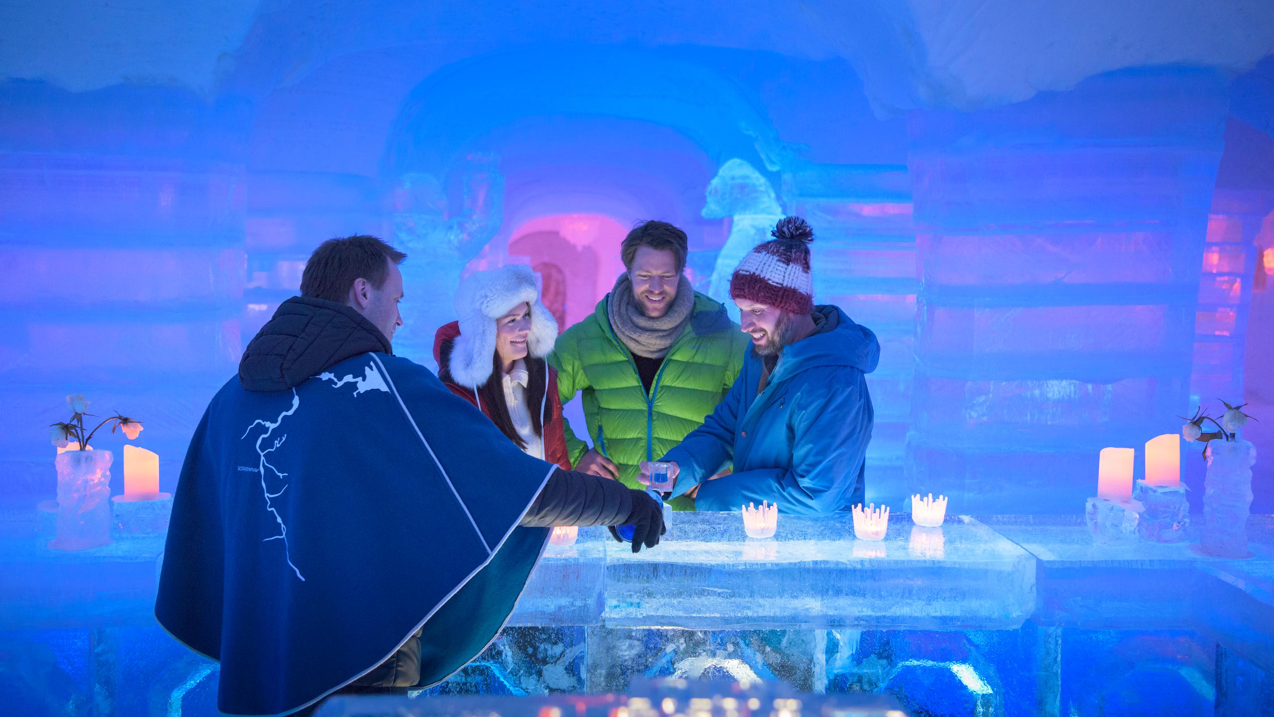 Four persons having a drink at the bar of the Sorrisniva Igloo Hotel in Alta, Northern Norway