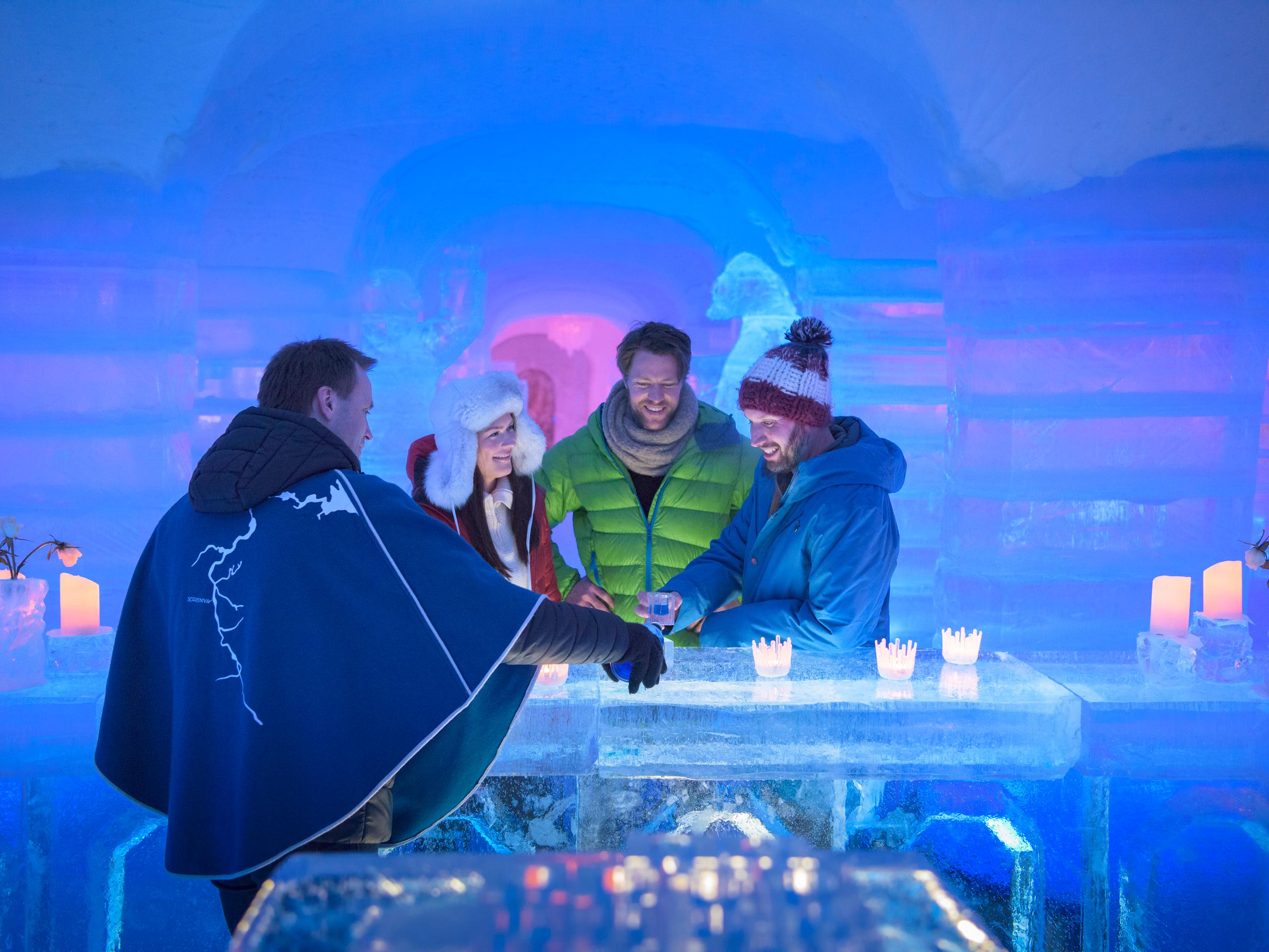 Four persons having a drink at the bar of the Sorrisniva Igloo Hotel in Alta, Northern Norway