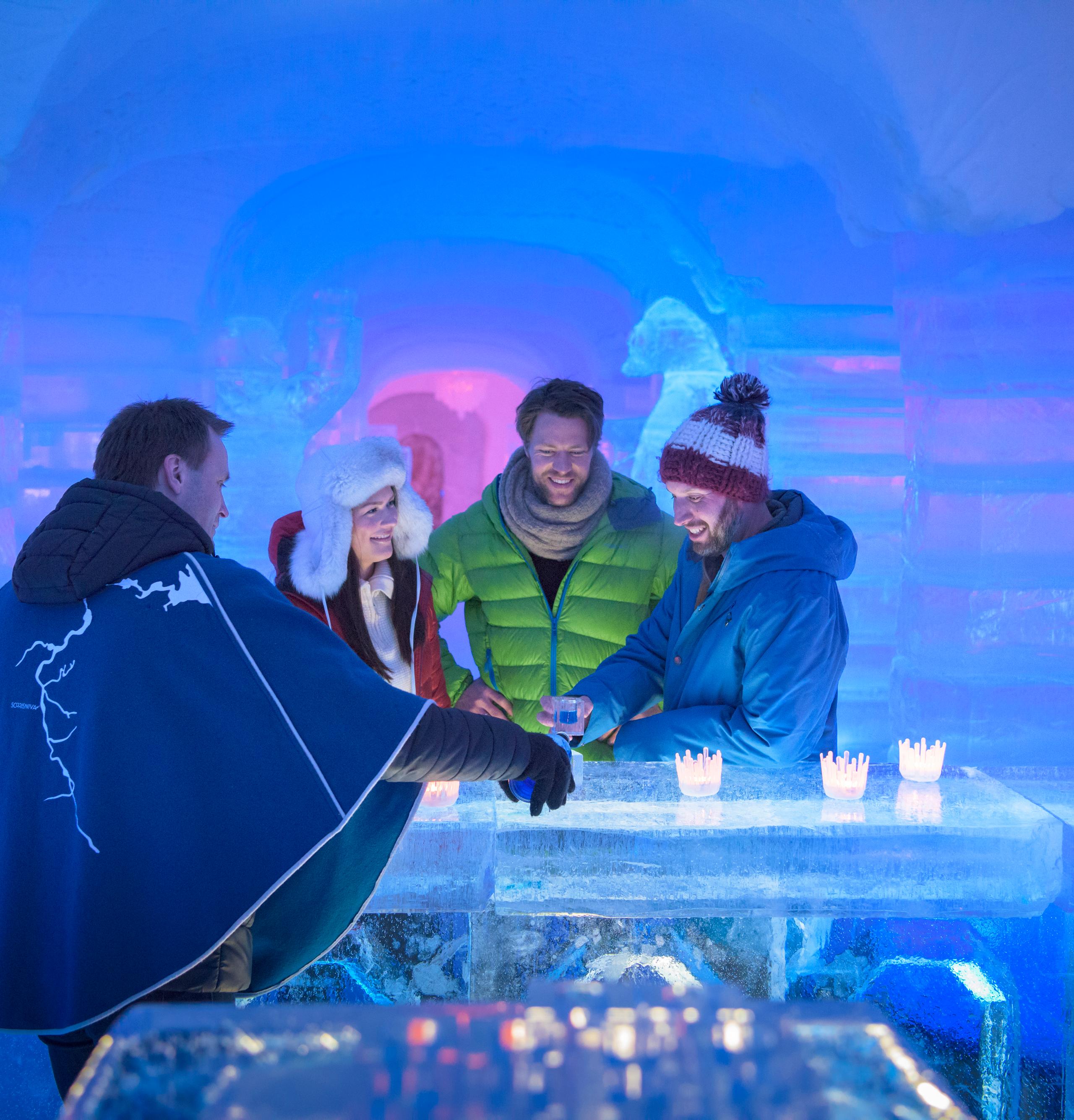 Four persons having a drink at the bar of the Sorrisniva Igloo Hotel in Alta, Northern Norway