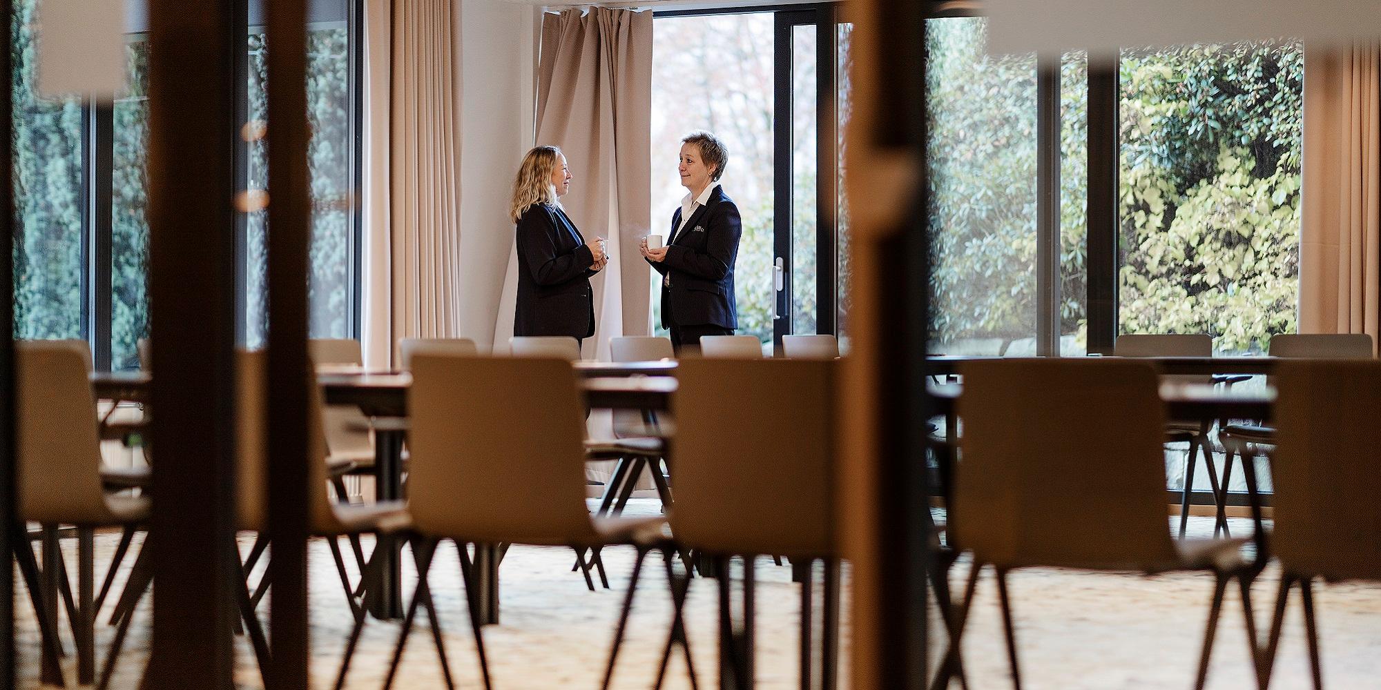 Staff at Hotel Alexandra in Loen, Norway, engaged in conversation in an empty dining room
