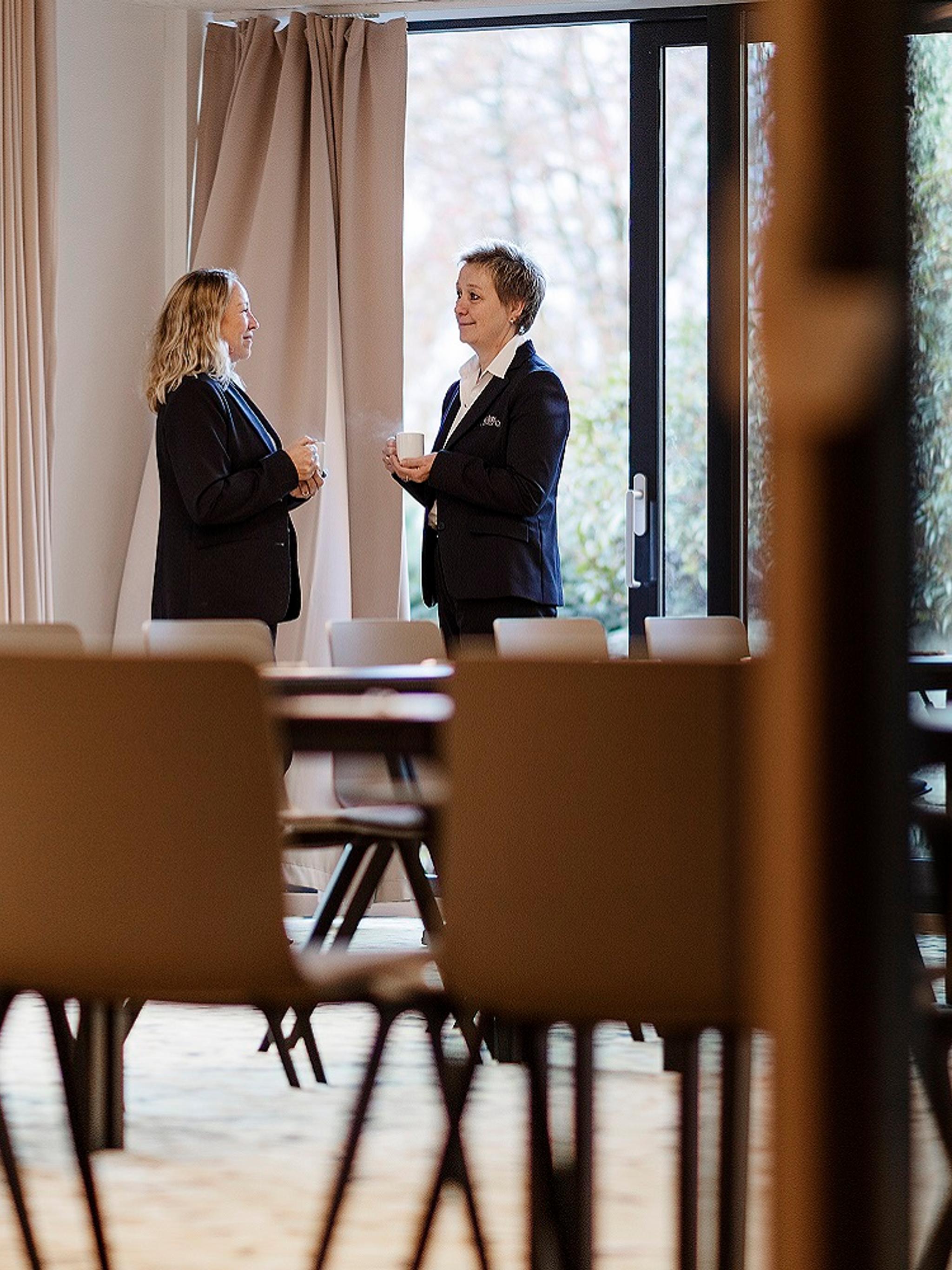 Staff at Hotel Alexandra in Loen, Norway, engaged in conversation in an empty dining room
