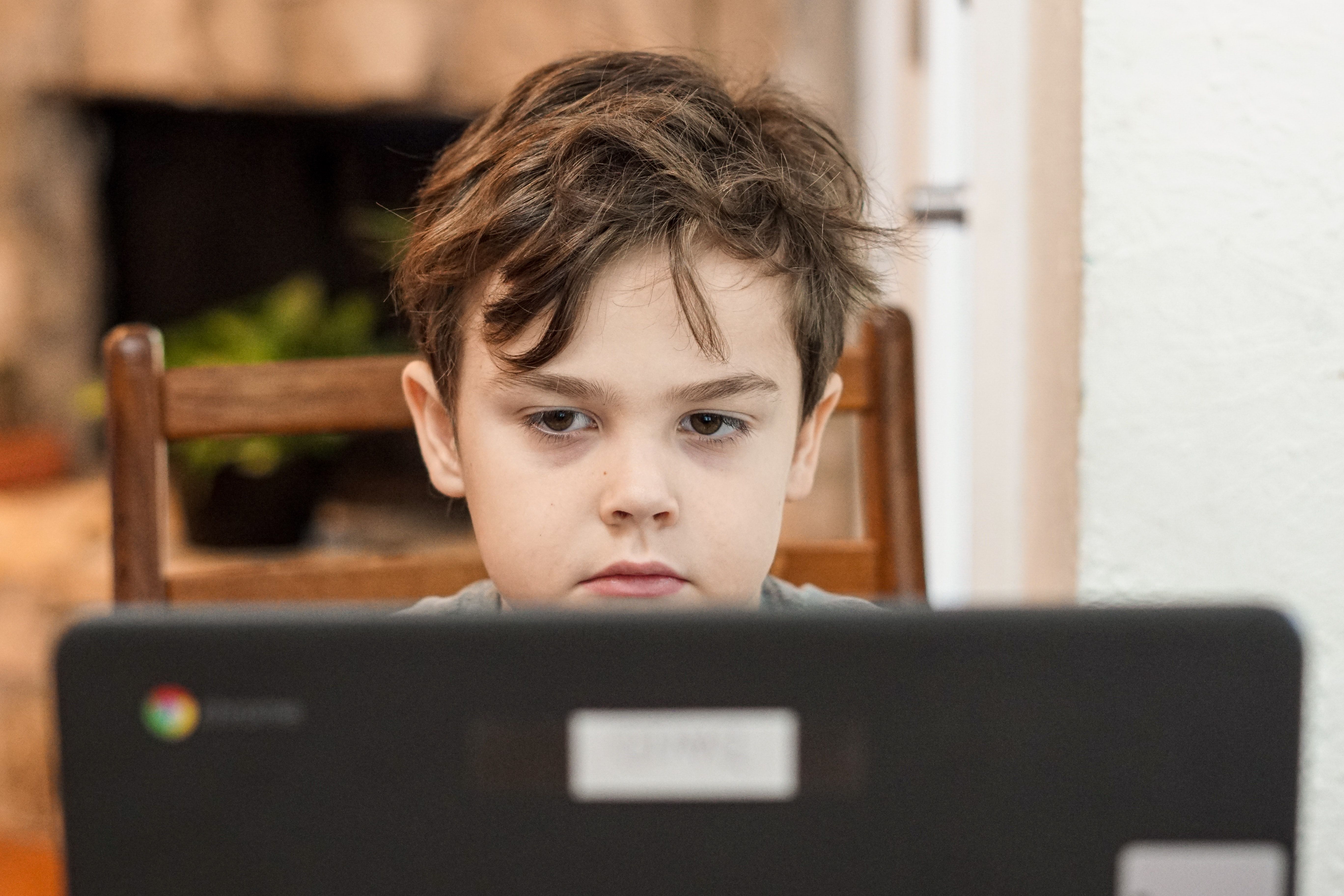 En gutt sitter foran pc-skjermen
