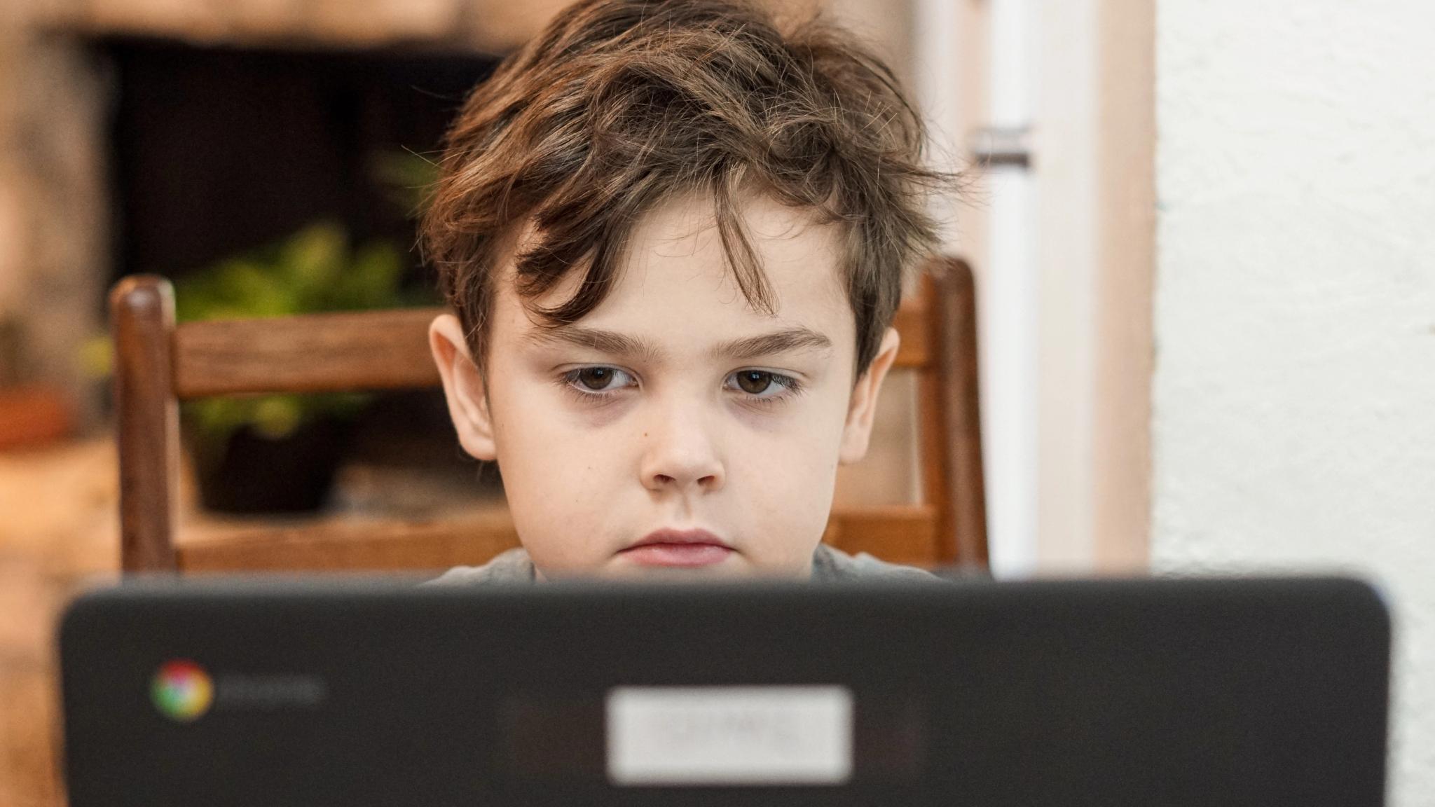 En gutt sitter foran pc-skjermen