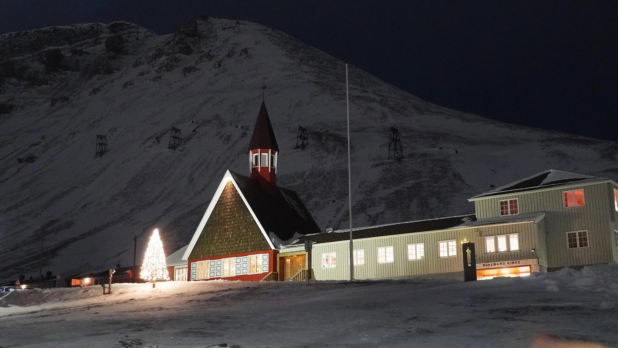 Svalbard Kirke foran et stort, hvitt fjell