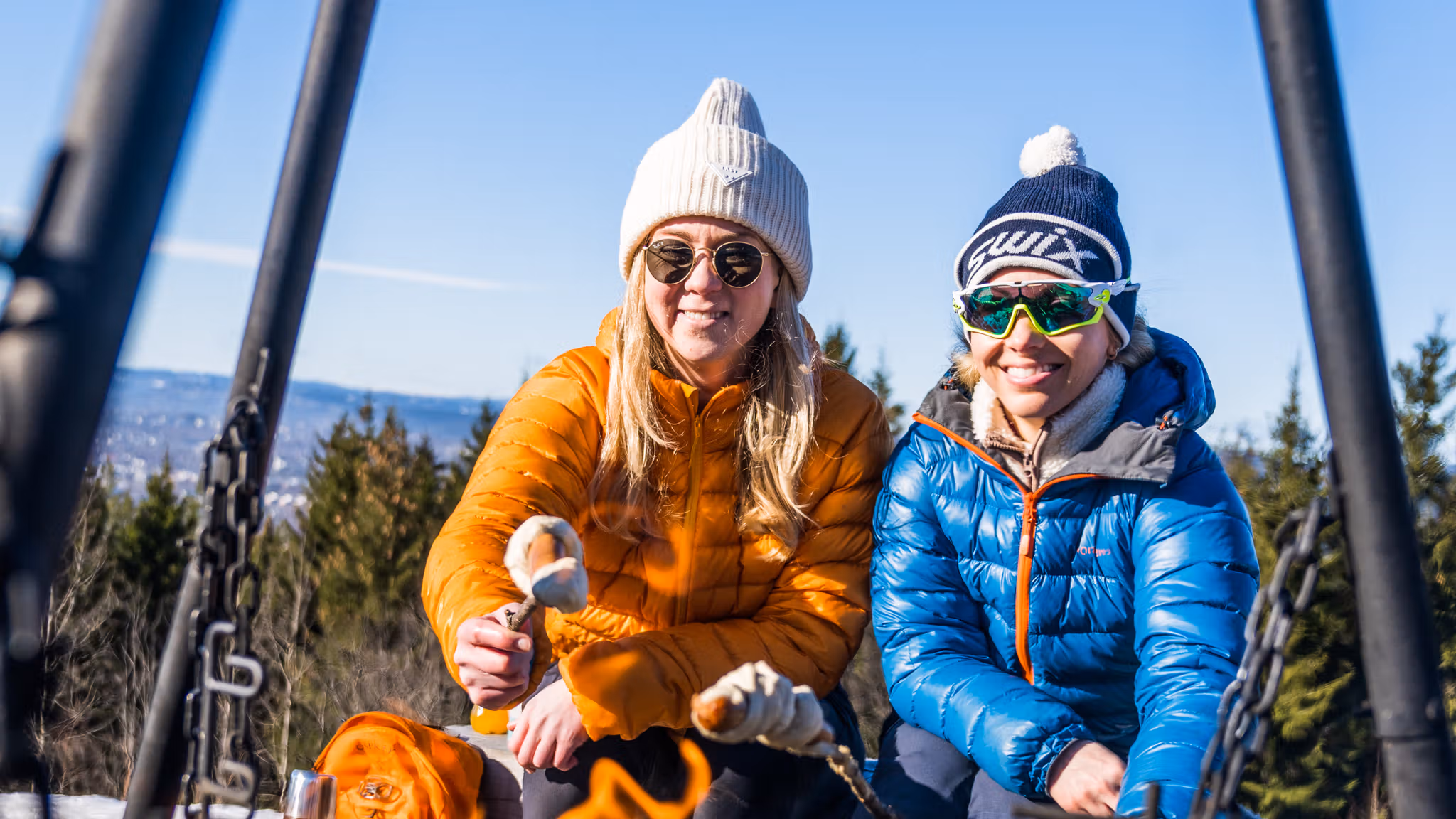 People making pinnebrød at the campfire in the woods, Grefsenkollen, Norway