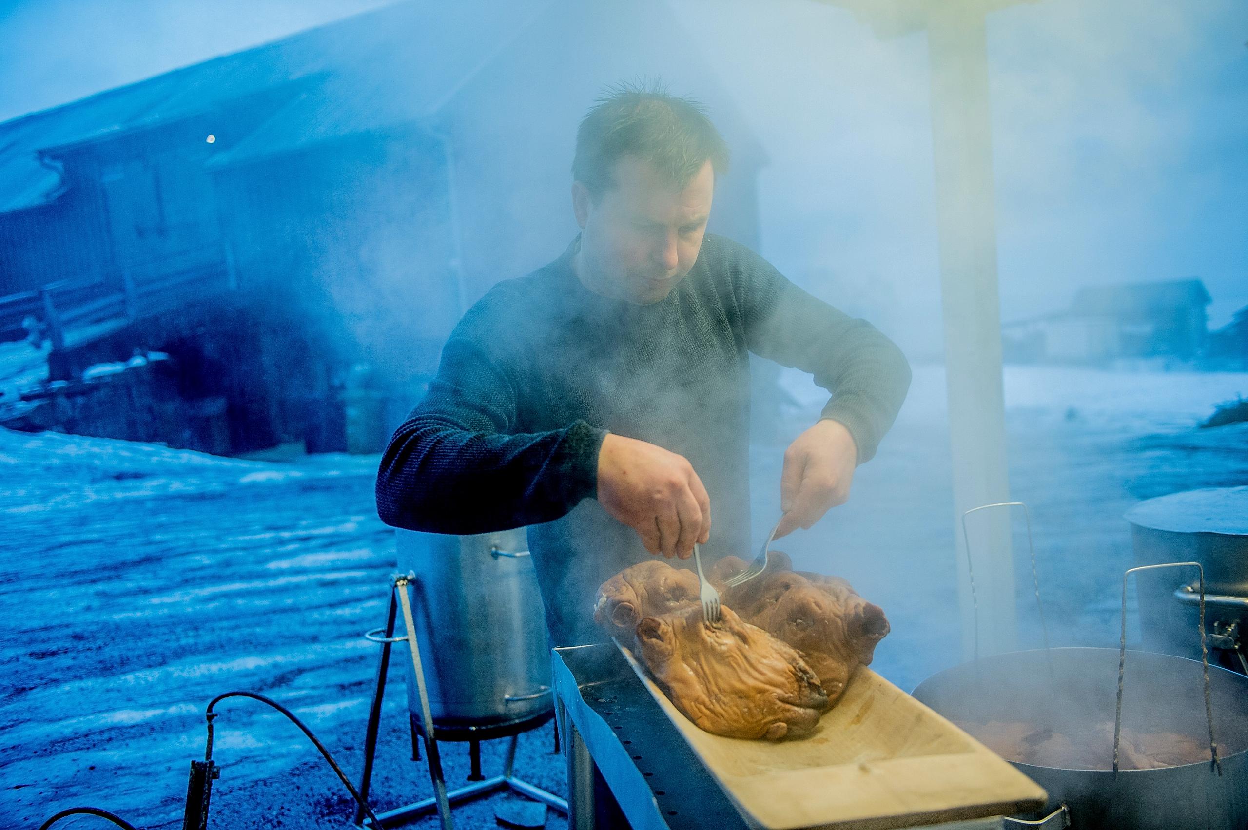 A person preparing a smalahove sheep’s head at Smalahovetunet in Voss, Fjord Norway