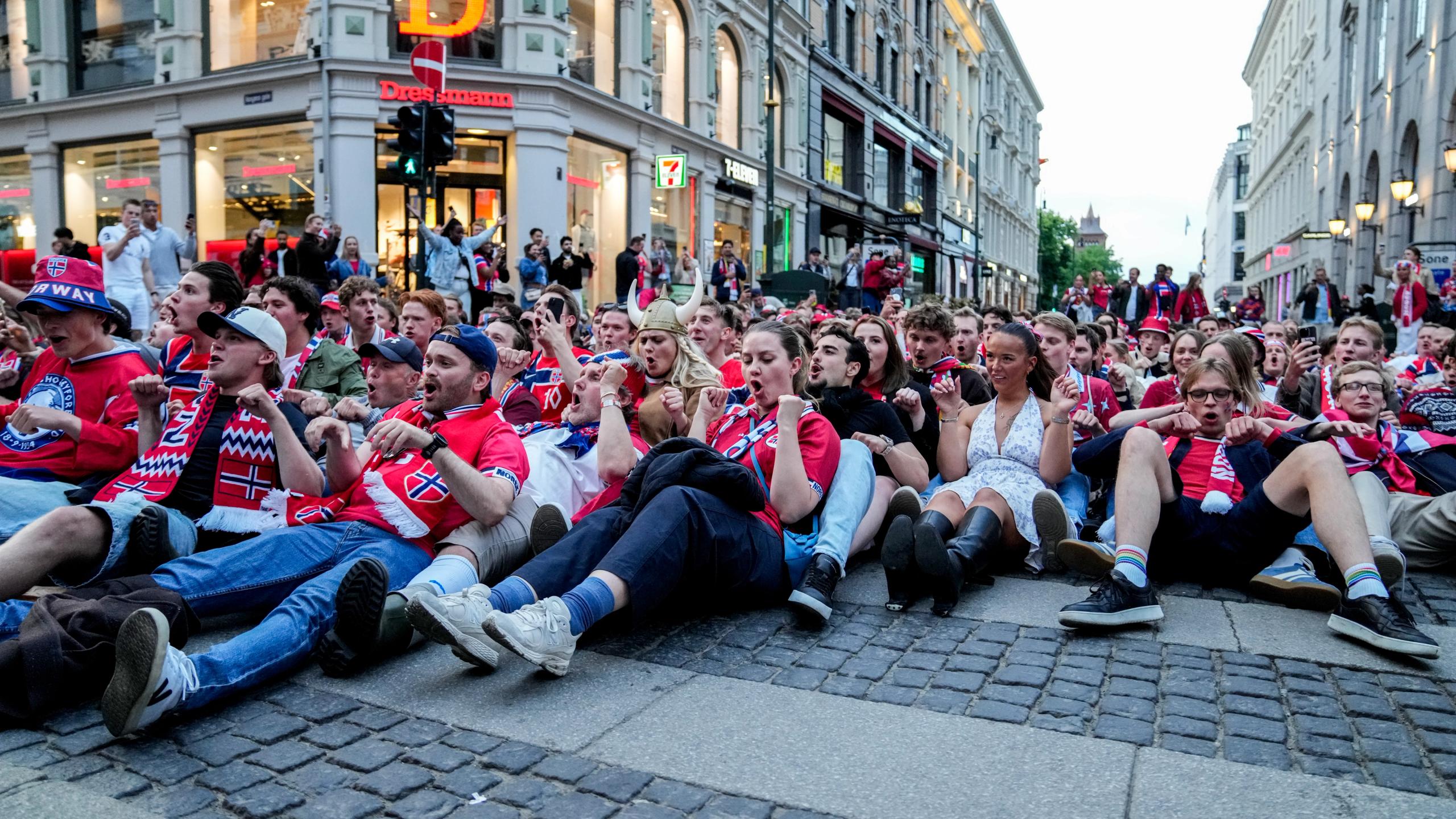 Many Norwegians sitting on the Karl Johan street and doing the Viking row