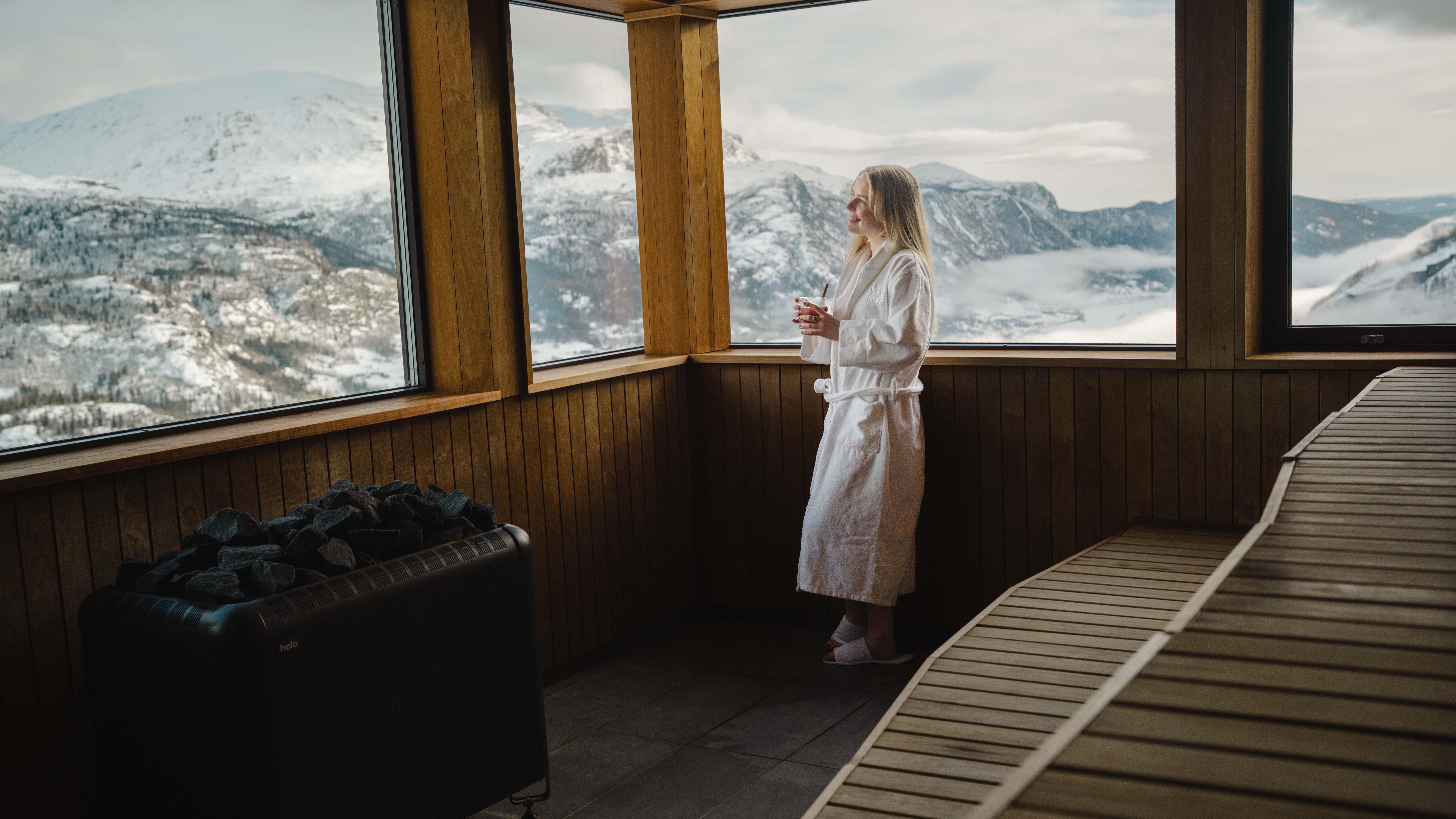 Ei dame slapper av på spa på Skarsnuten mens en annen står på ski utenfor