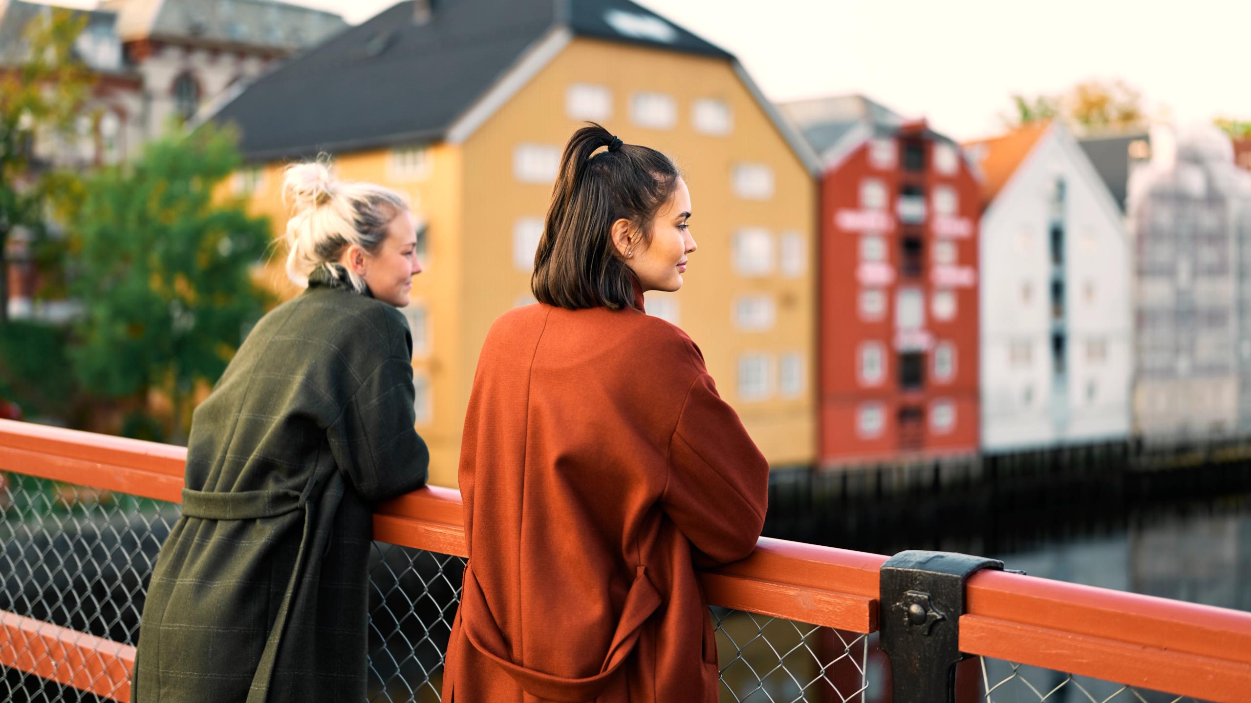 To kvinne står og nyter utsikten fra gamle bybro i Trondheim