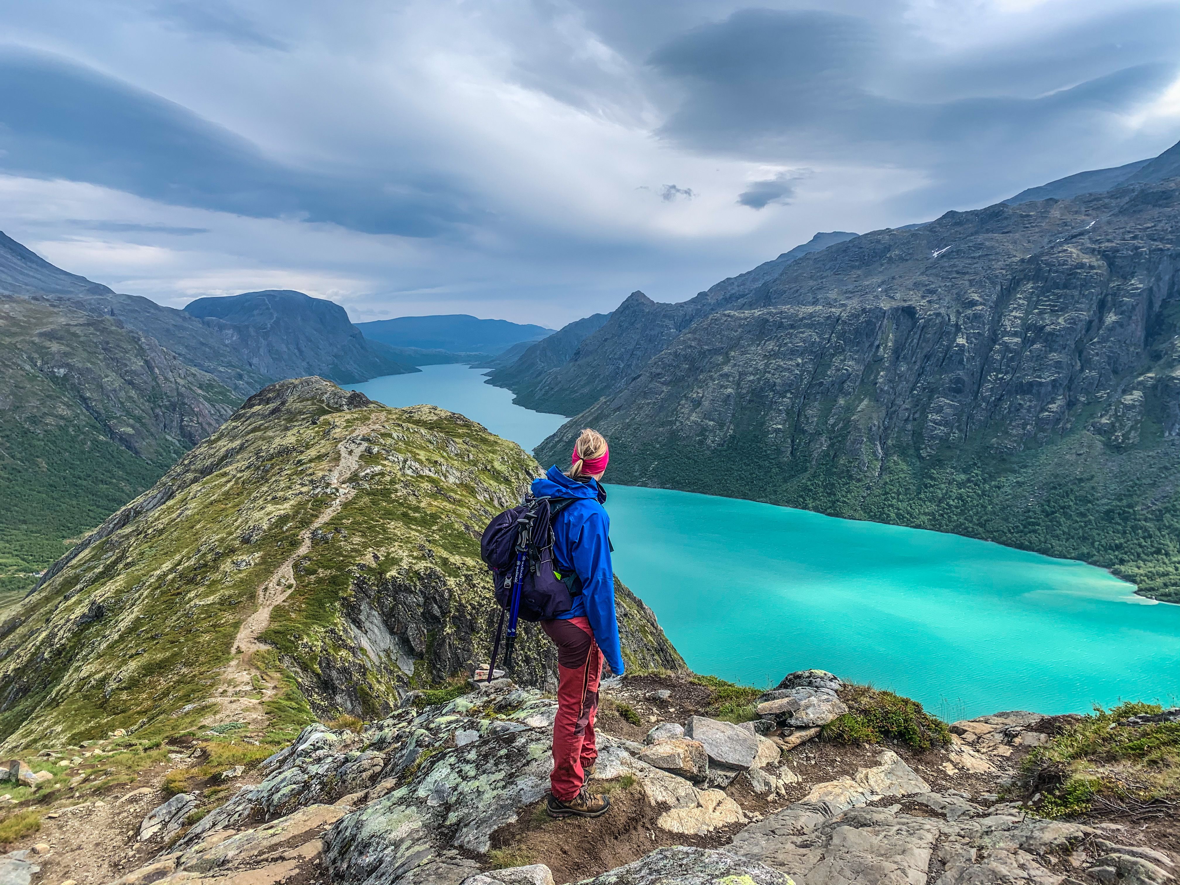 A woman hiking and looking at the Gjendevatnet lake
