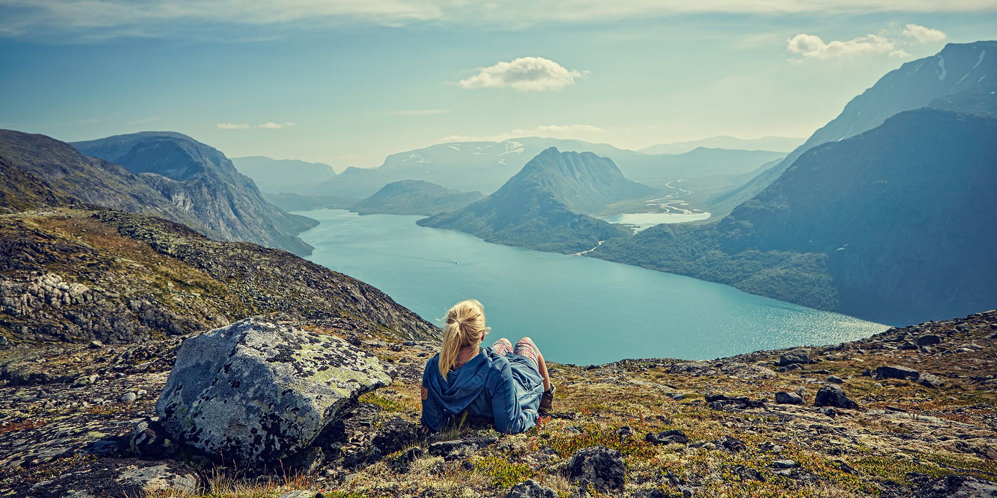 Eine Frau blickt über den See Gjende in den Jotunheimen Bergen in Ostnorwegen
