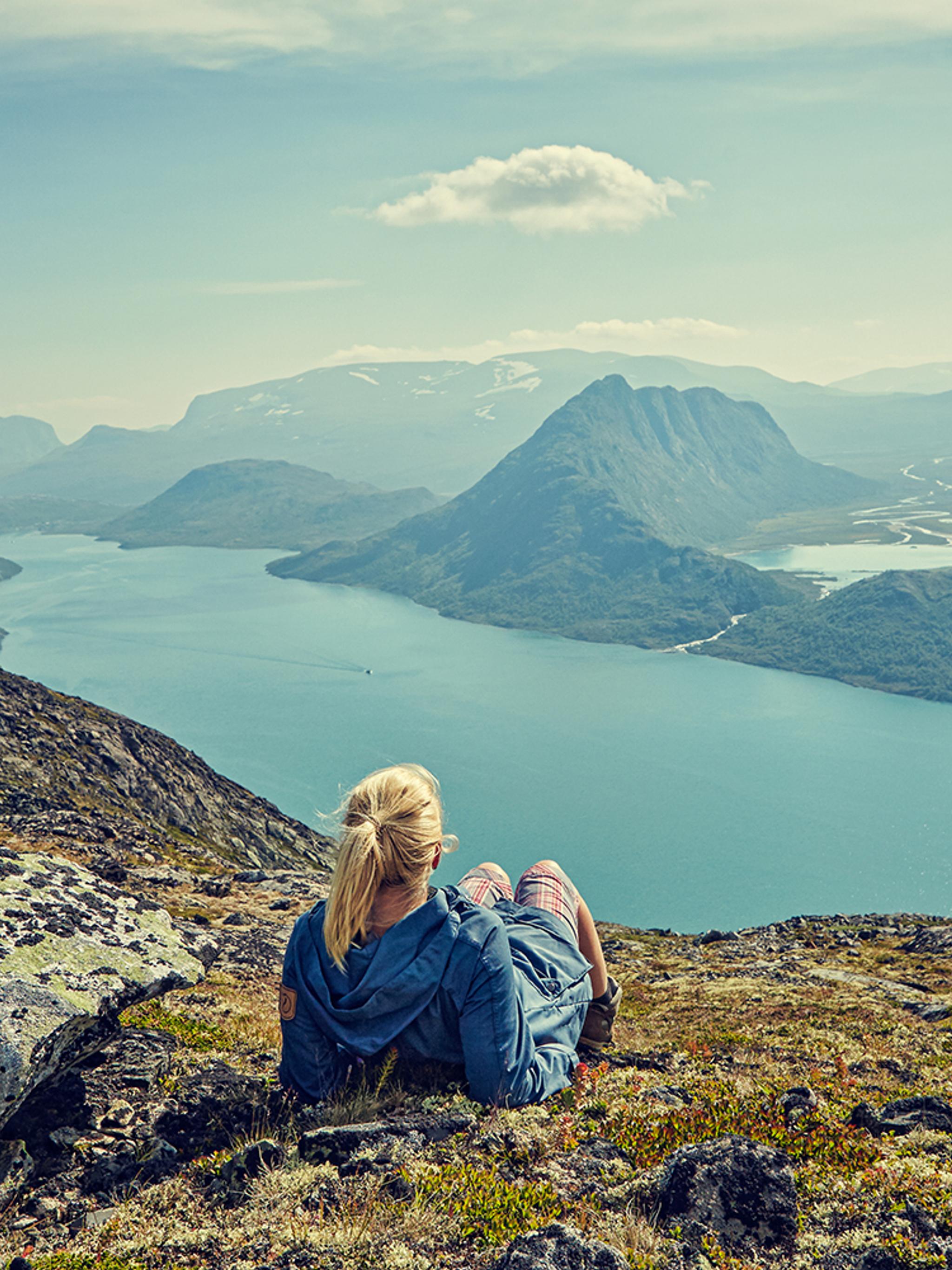 Eine Frau blickt über den See Gjende in den Jotunheimen Bergen in Ostnorwegen
