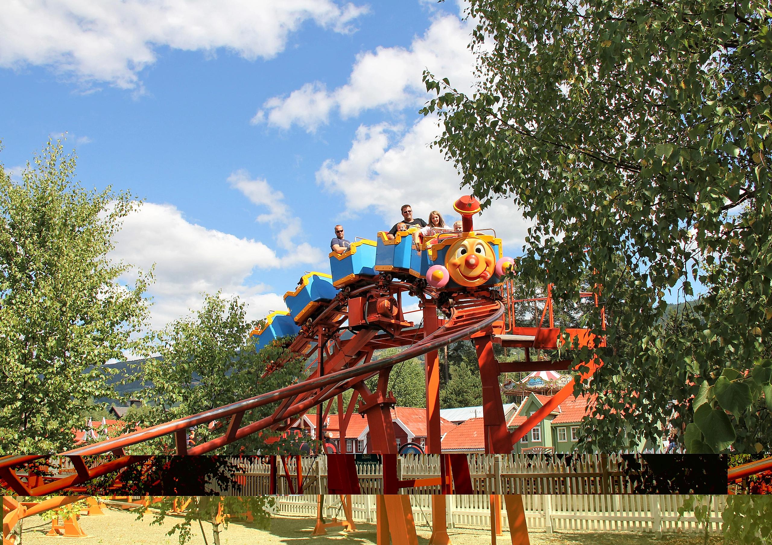 A family riding a carousel in Lilleputthammer amusement park, Norway