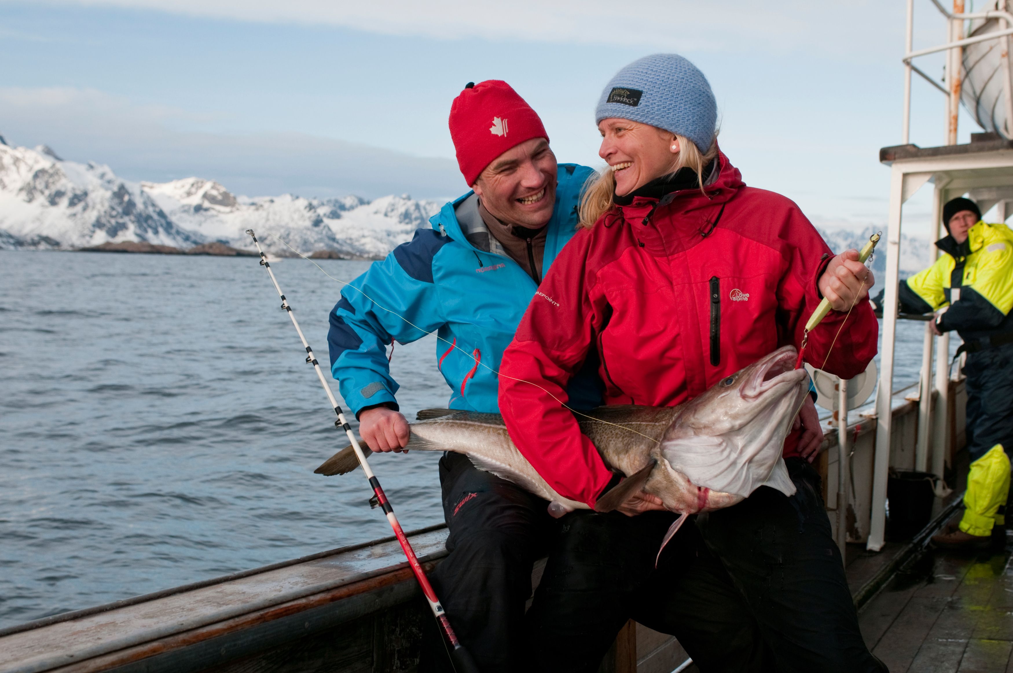 A woman and a man holding a newly caught cod in Lofoten in Northern Norway