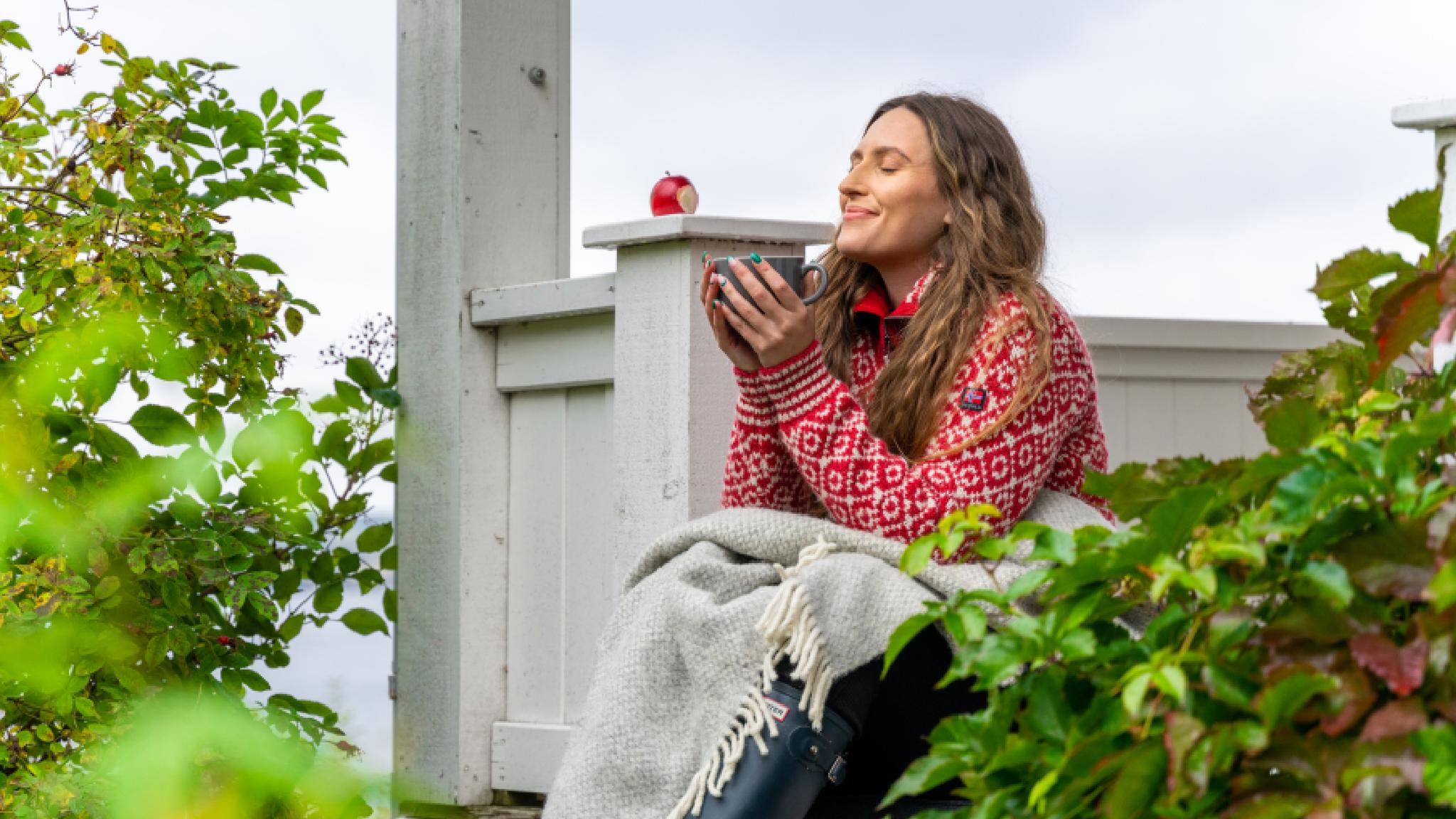 A woman having a good time in the garden at the farm Hoel Gård at Nes, Eastern Norway.