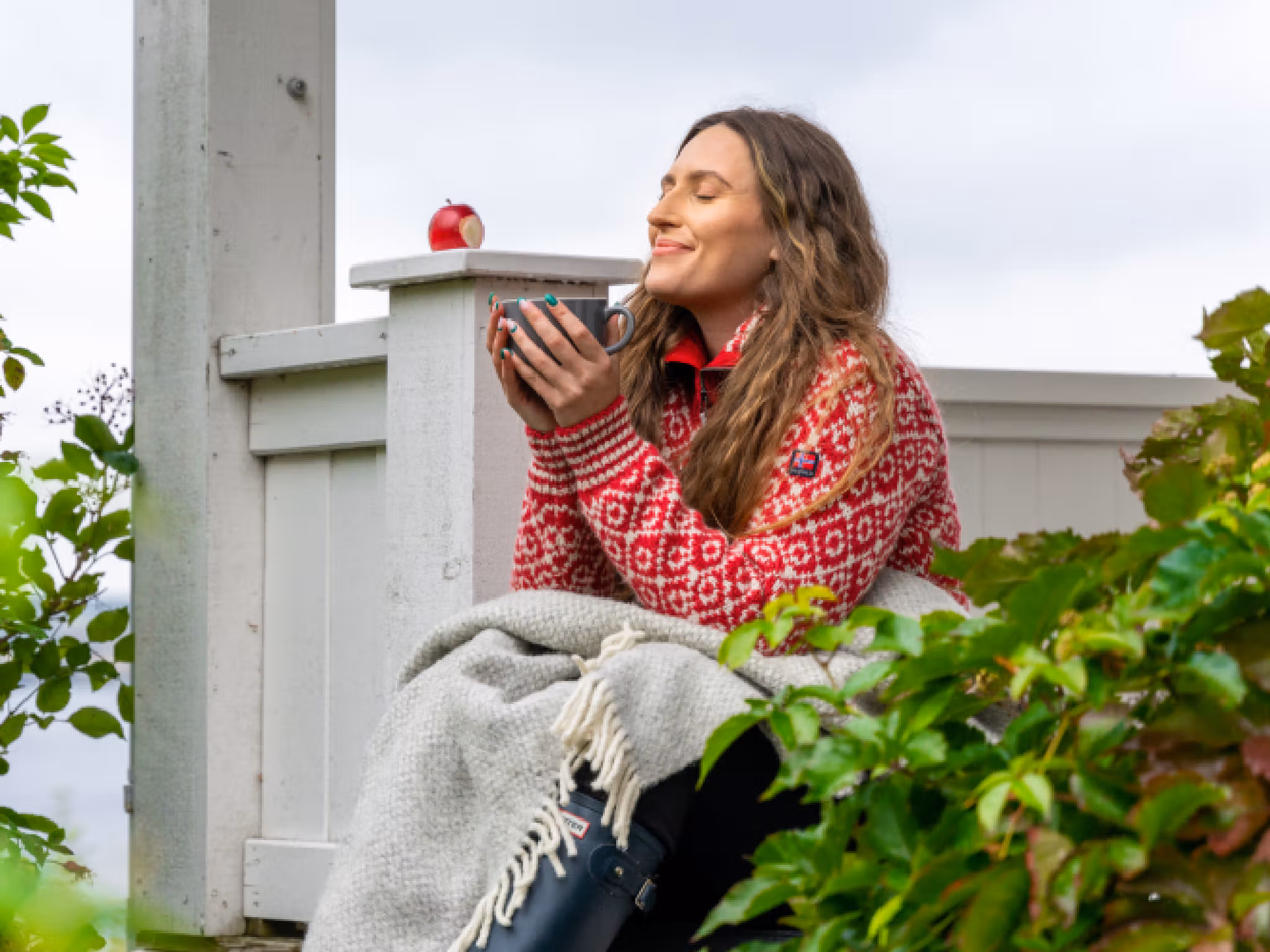 A woman having a good time in the garden at the farm Hoel Gård at Nes, Eastern Norway.
