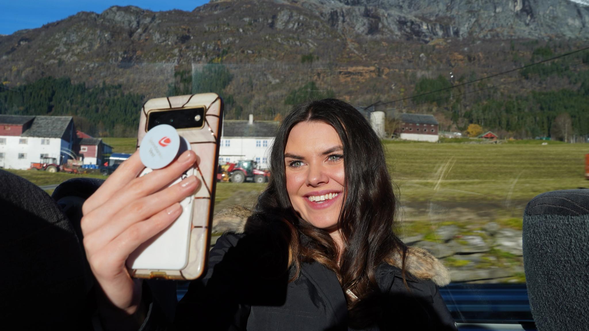 Kvinne tar selfie på en buss