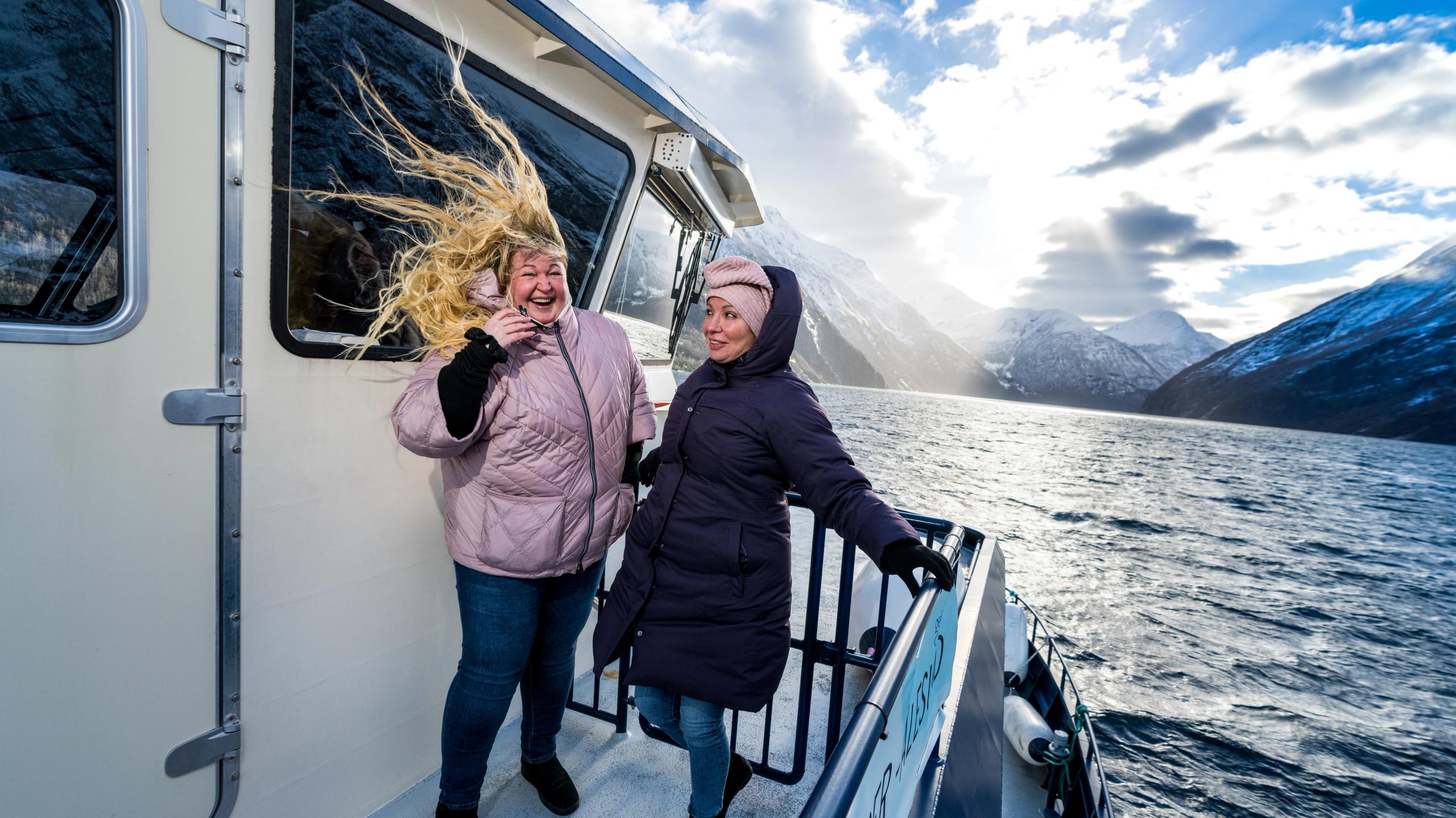 Two women in the wind at Fjordrangers cruise to Geiranger, in winter
