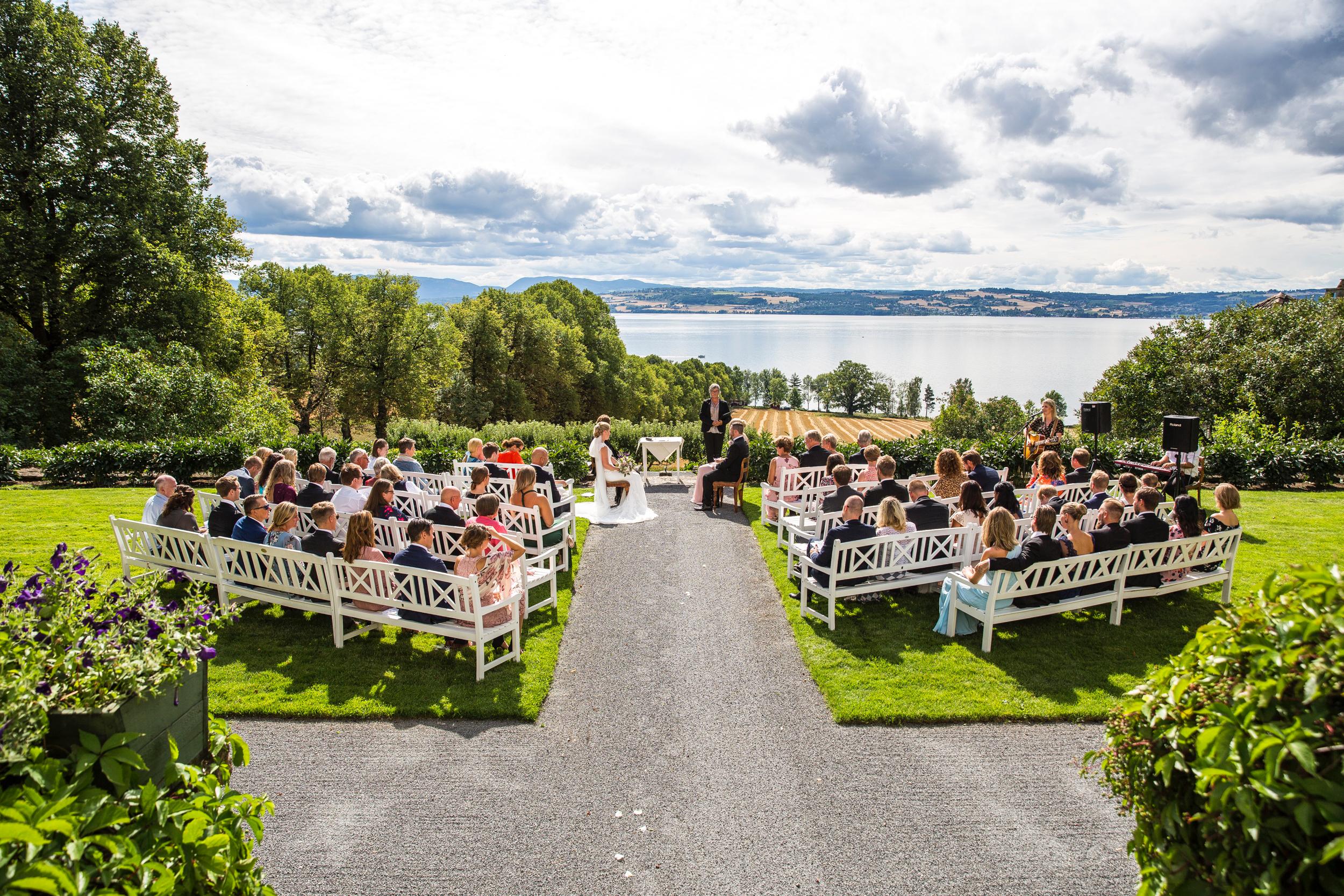 A wedding ceremony outside at the lawn at Hoel Farm by lake Mjøsa in Eastern Norway