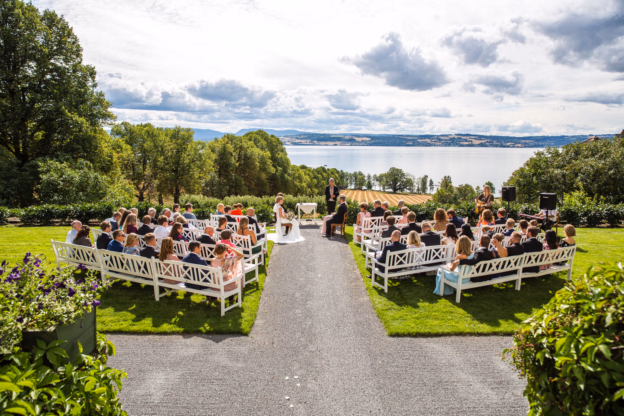 A wedding ceremony outside at the lawn at Hoel Farm by lake Mjøsa in Eastern Norway