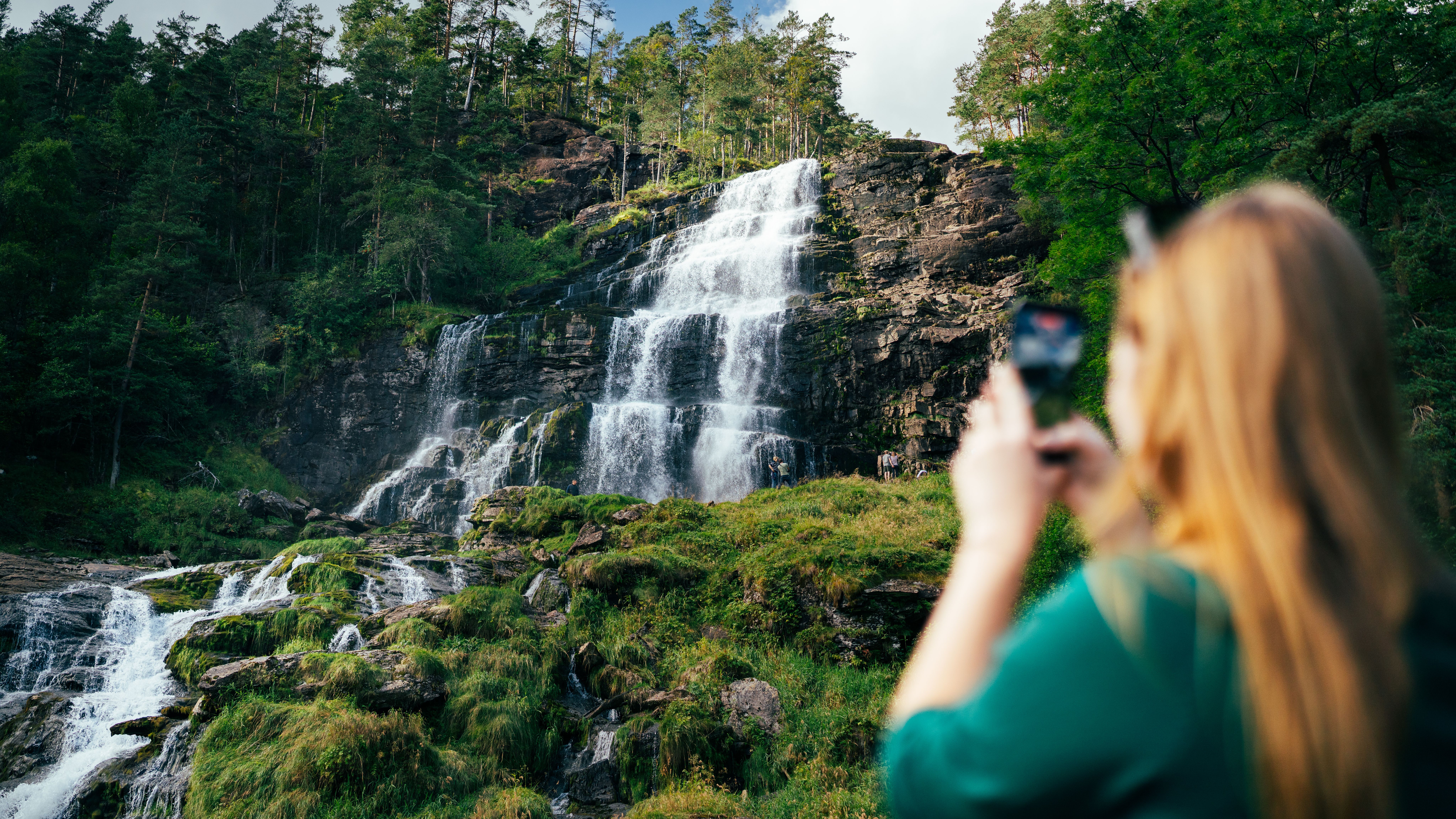 People taking pictures of a waterfall.