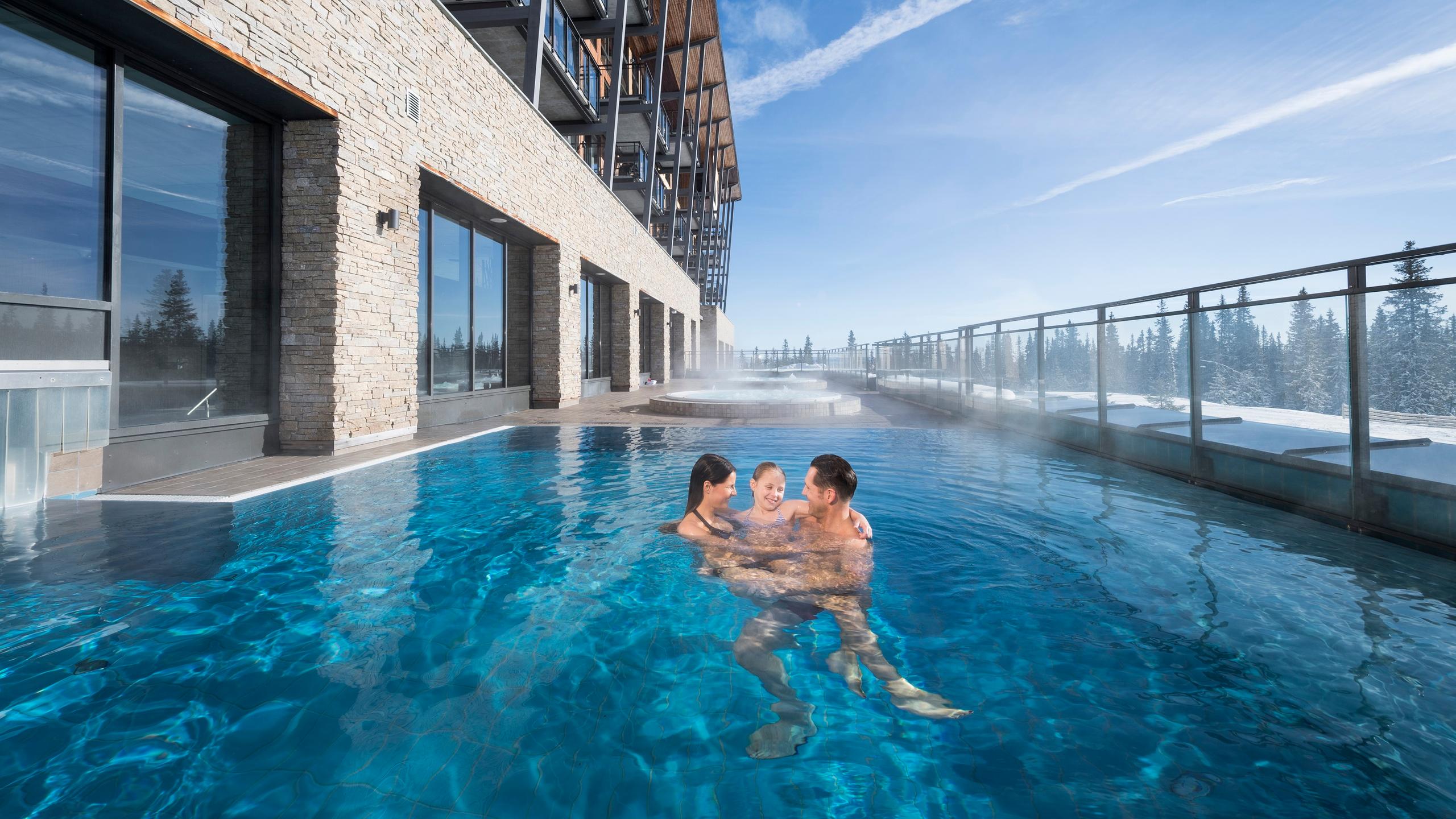 Familie i utendørsbassenget en vinterdag på Radisson Blu Resort i Trysil på Østlandet