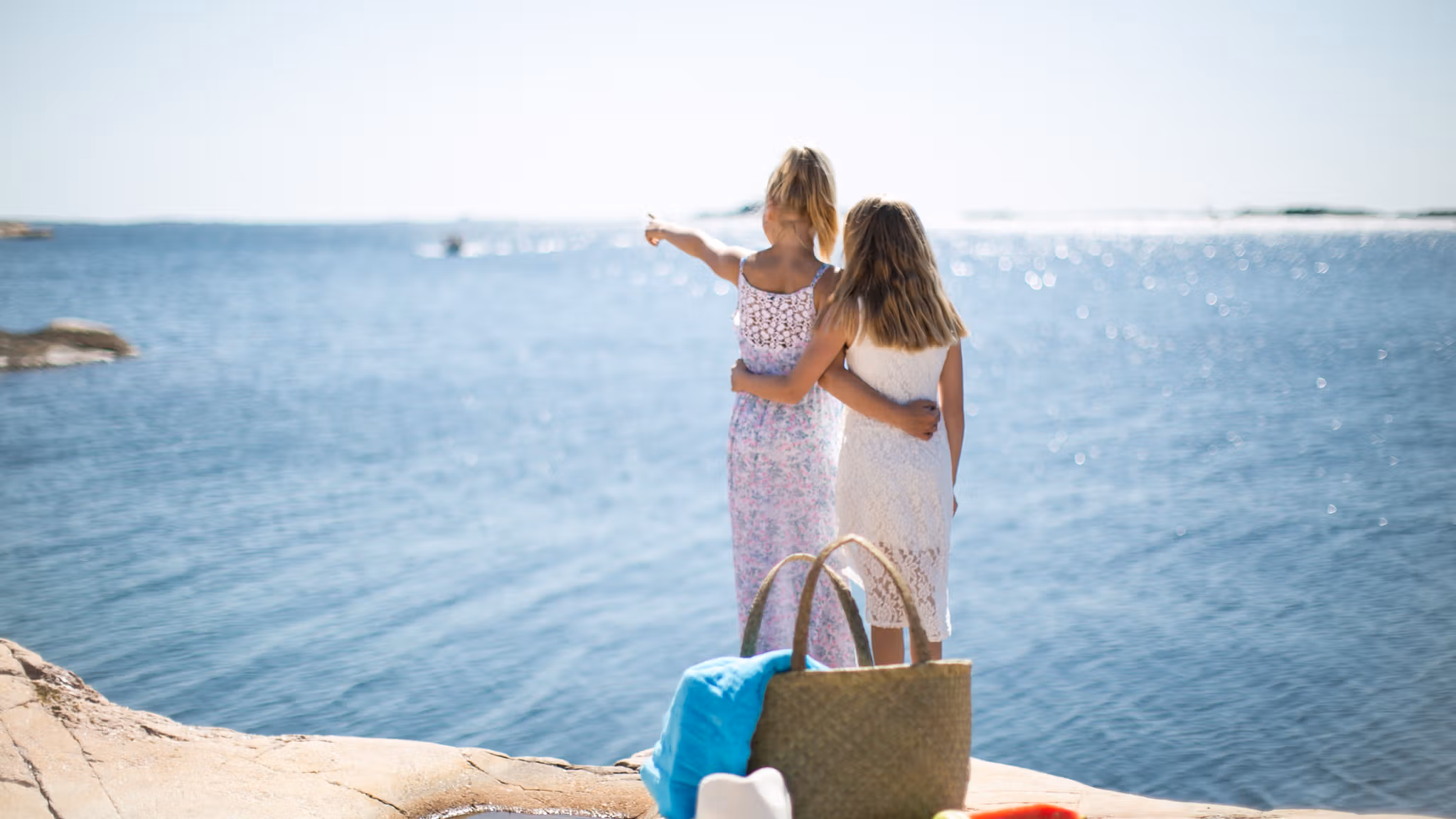 Dos niñas miran hacia el mar desde la isla de Bragdøya, en Kristiansand (Sur de Noruega), en un soleado día de verano.