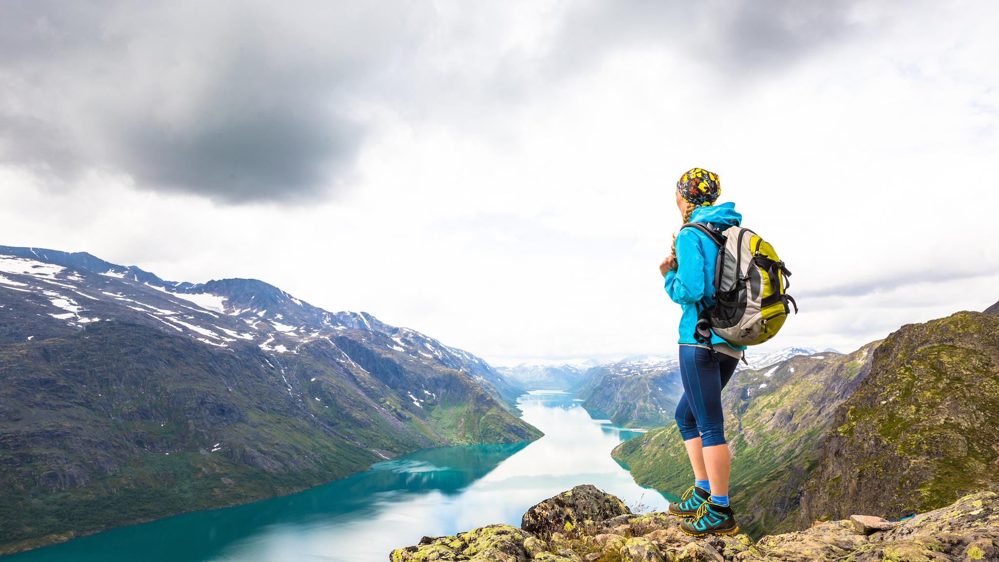 Una mujer disfruta de las vistas del lago Gjende desde lo alto de Besseggen, en Jotunheimen, Este de Noruega.