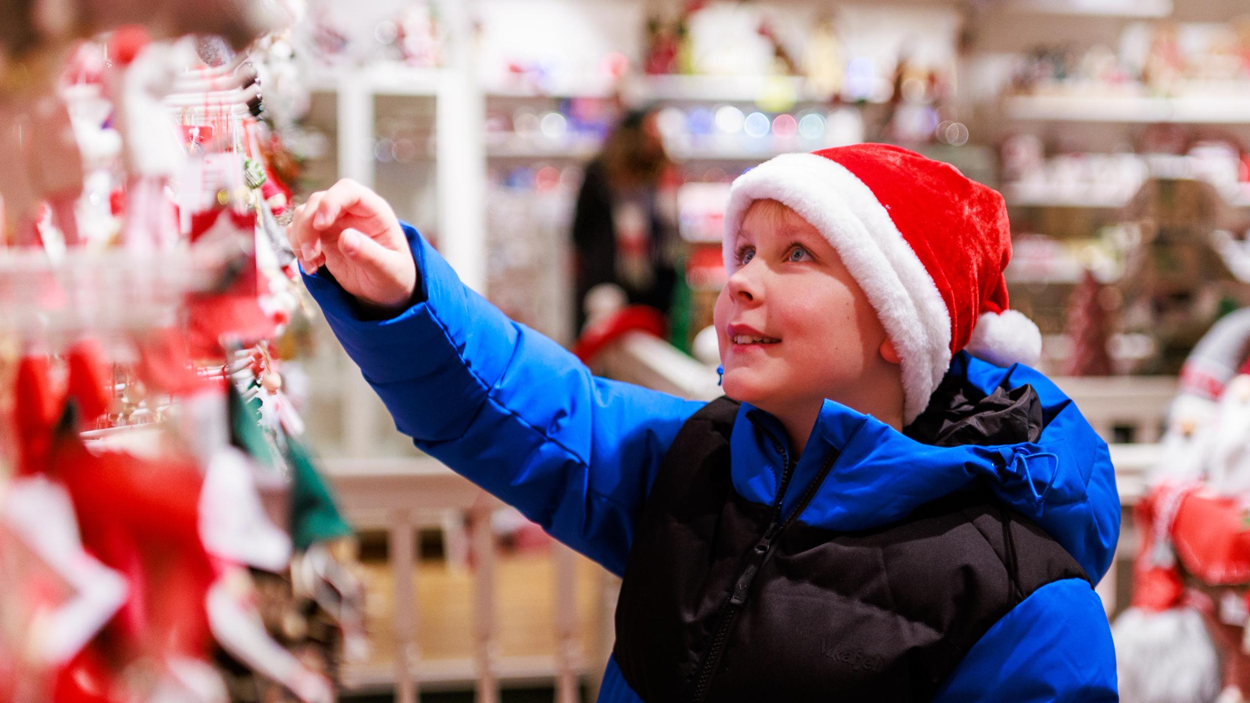 Boy looking at Christmas ornaments at the Christmas store Audhild Viken in Stavanger
