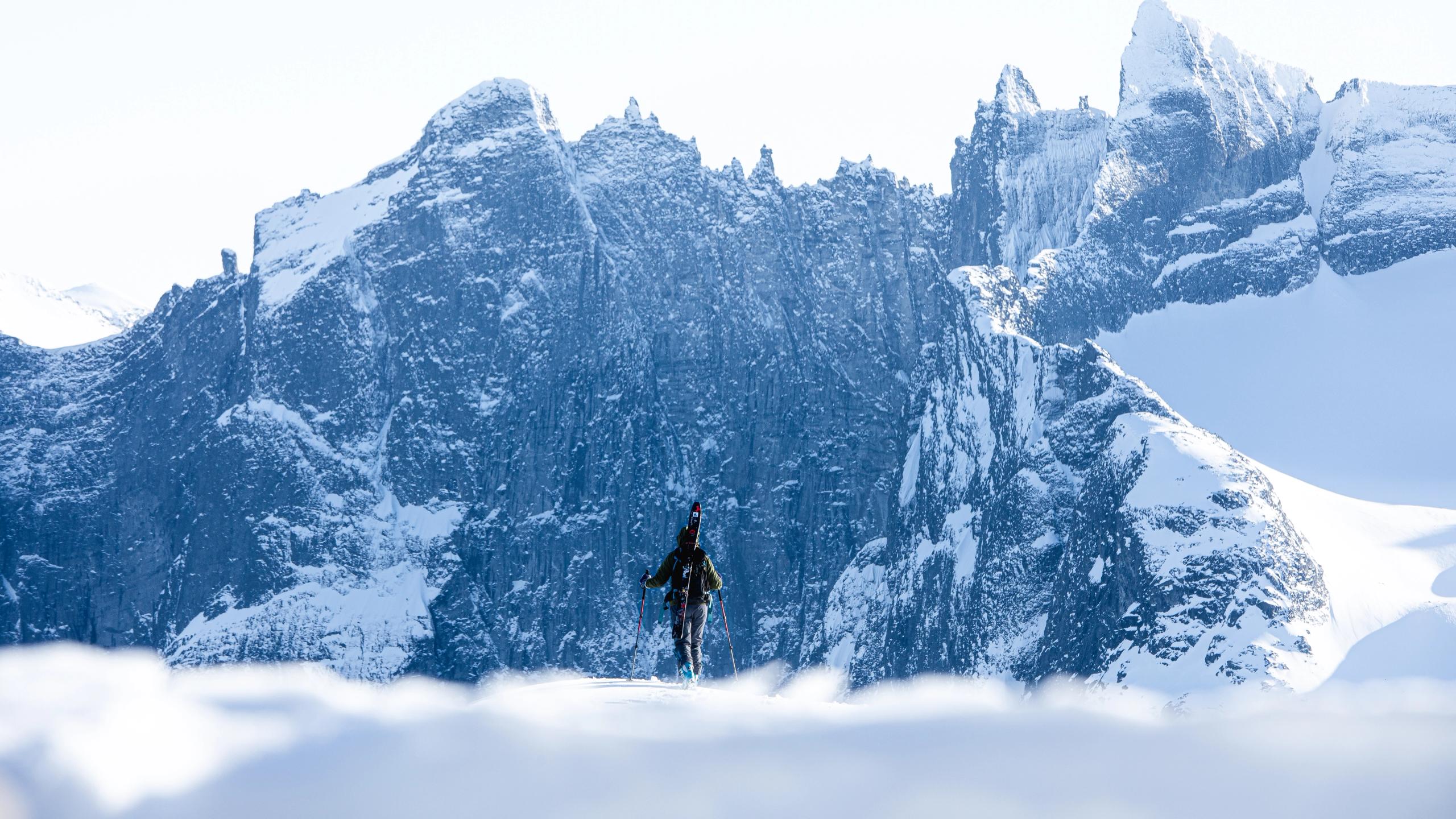 En person på ski fremfor Trollveggen dekket av snø