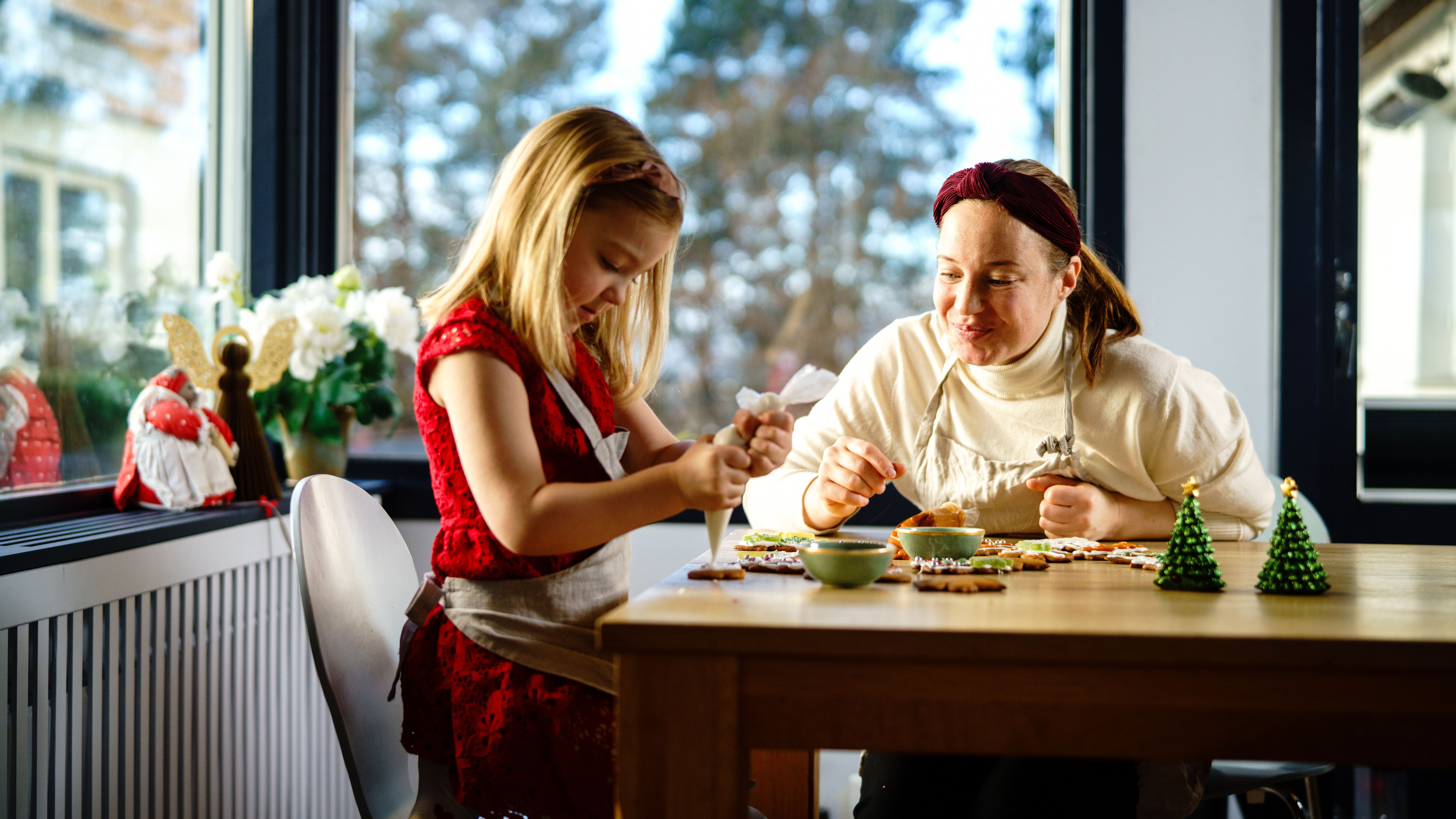 Mother and daughter decorating gingerbread together