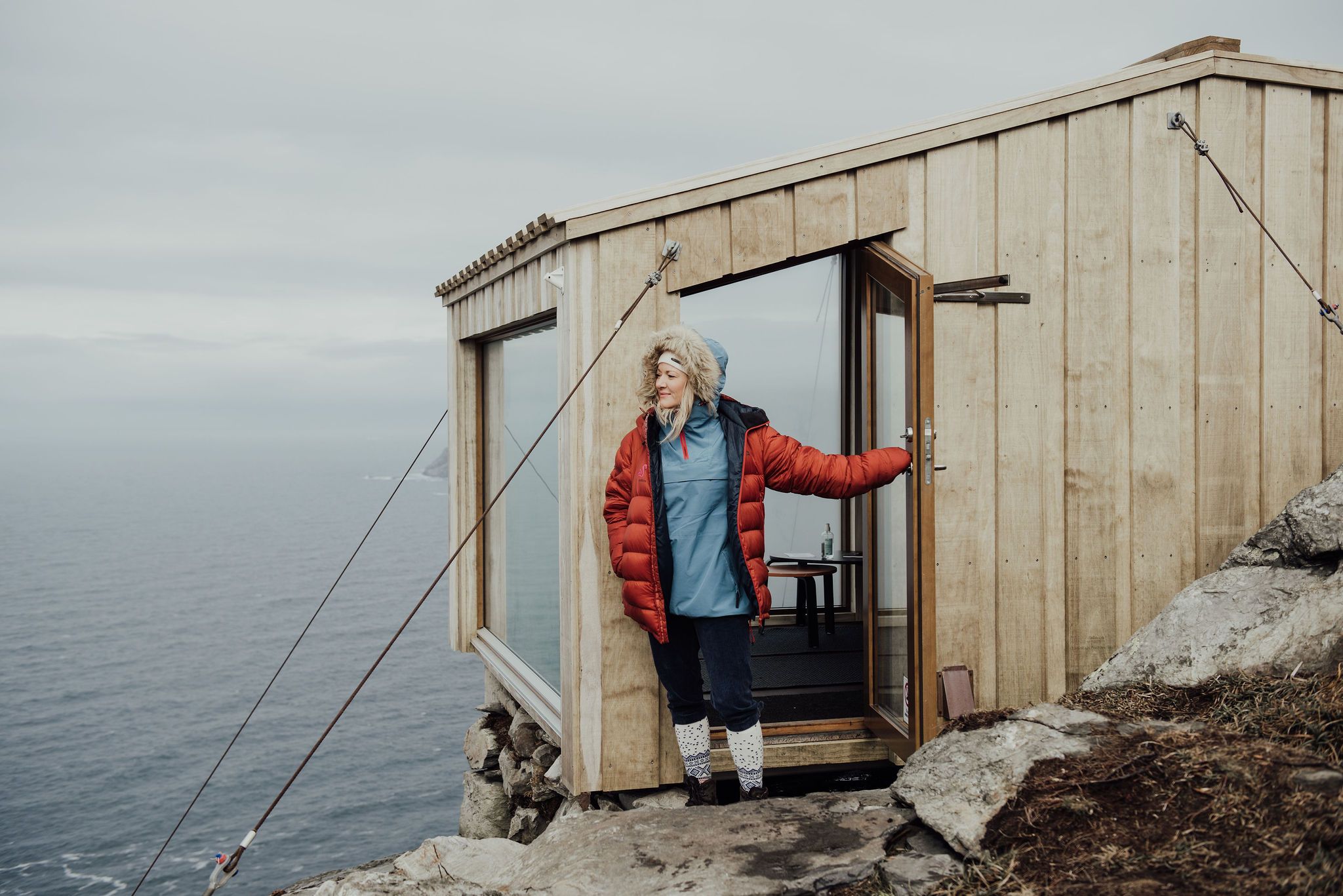 A woman stepping out of a cabin.