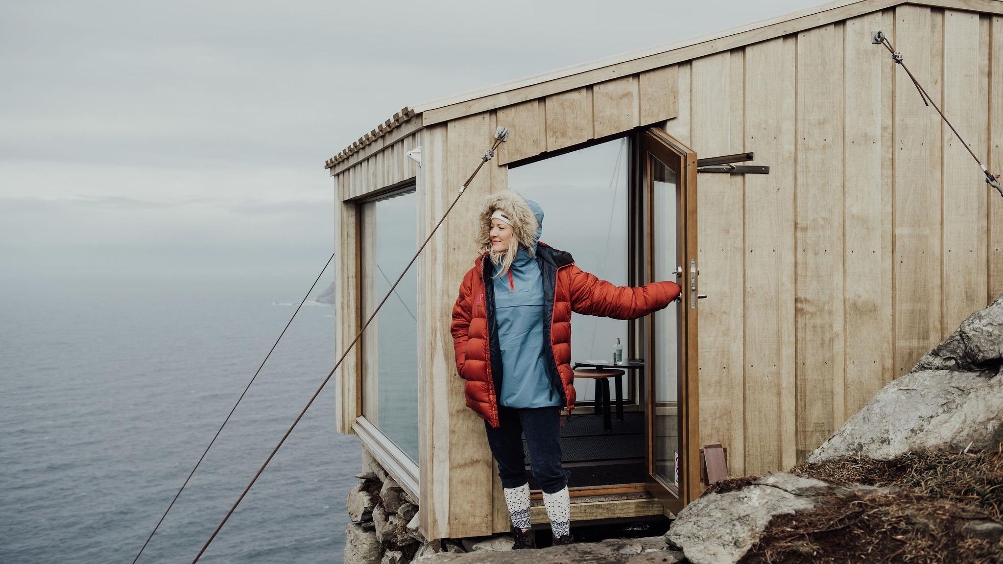 A woman stepping out of a cabin.