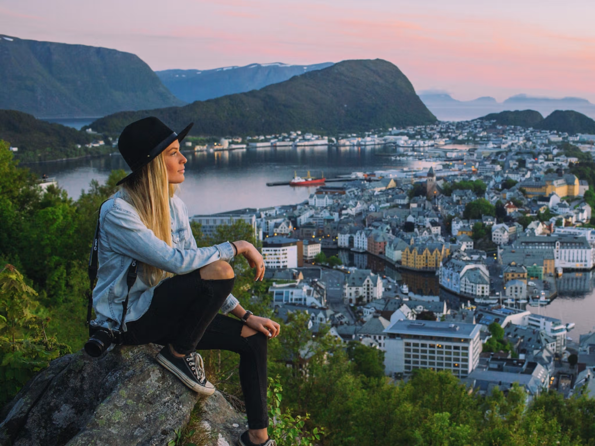 A woman on a city break in Norway is overlooking Ålesund from Aksla viewpoint