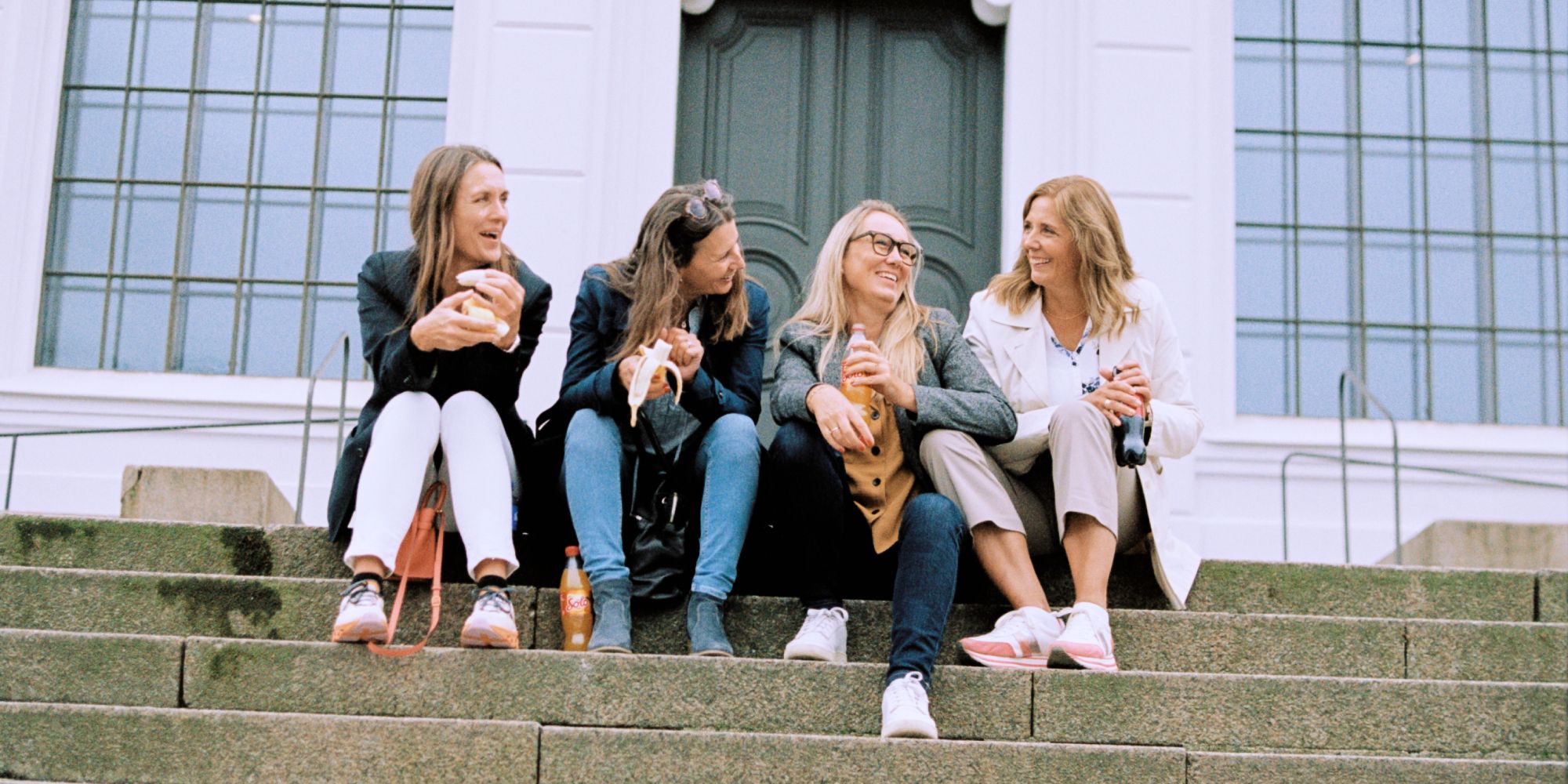 Fire kvinner sitter i en trapp