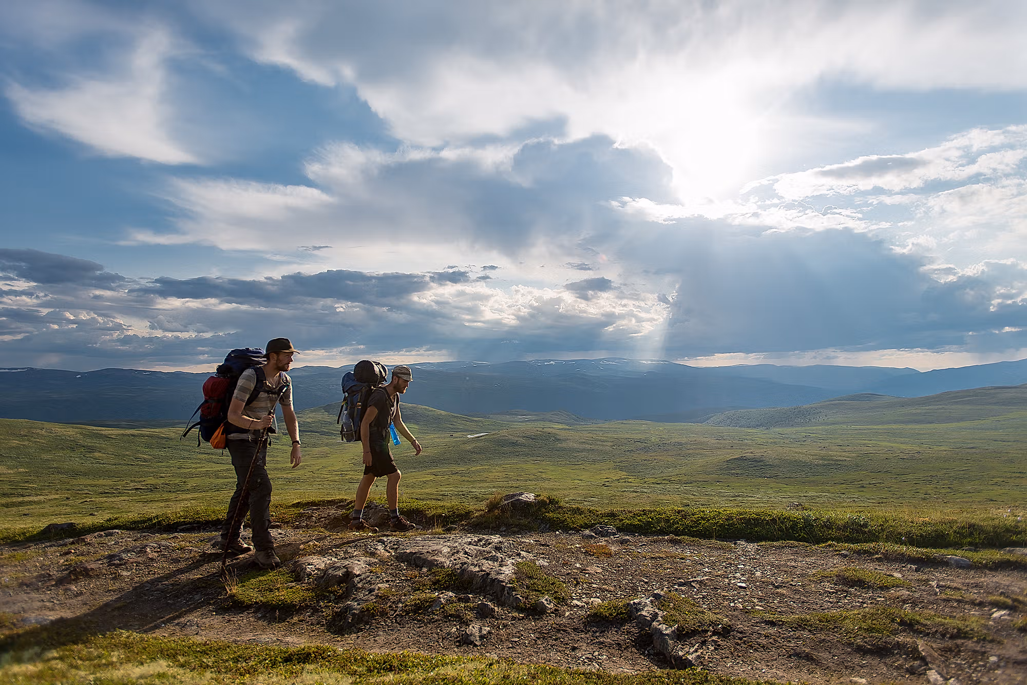 Two men wearing backpacks hiking the Gudbrandsdalen path, the pilgrim trail St. Olav Ways to Trondheim, across Dovrefjell in Eastern Norway