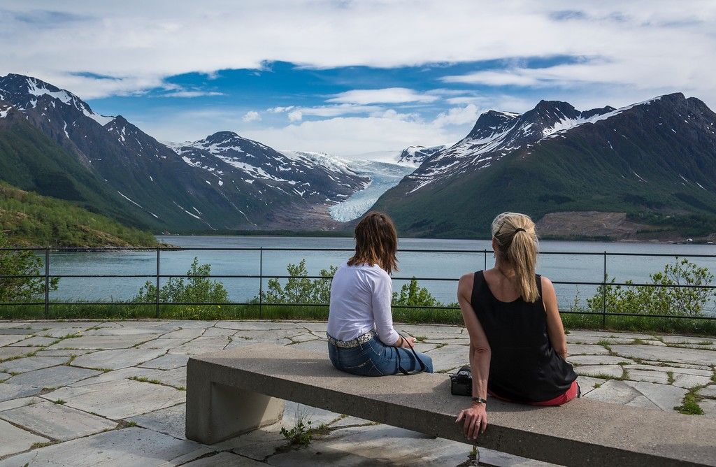 Two women looking at Engabreen glacier from afar.