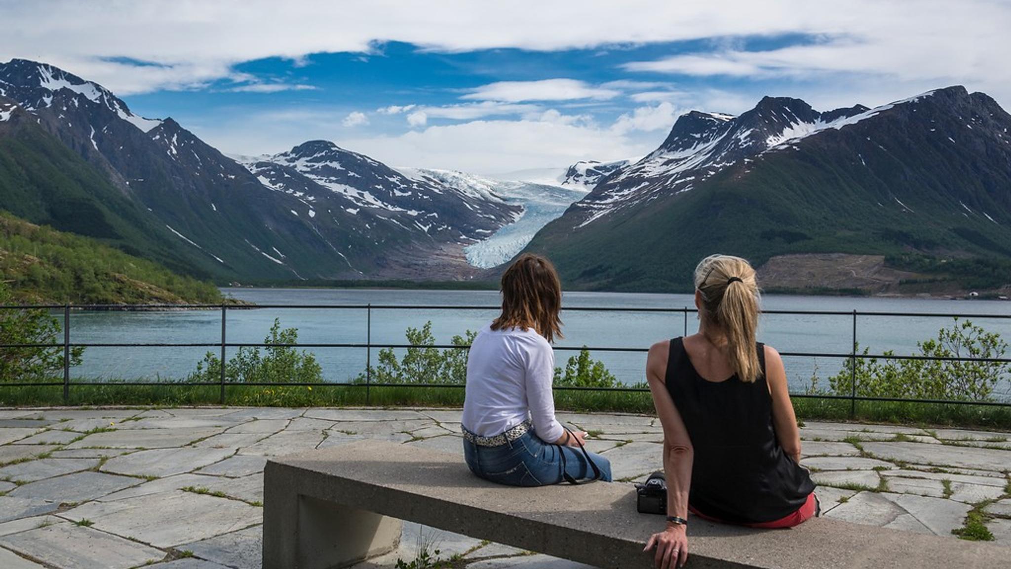 Two women looking at Engabreen glacier from afar.