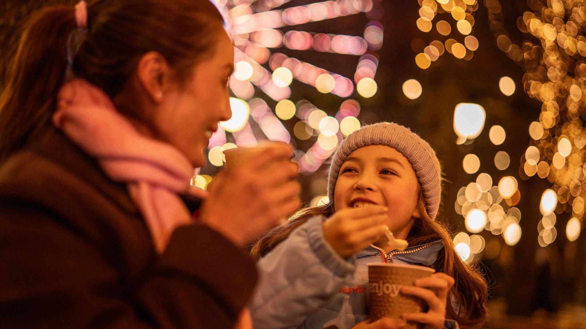 A girl and a women enjoying porrige at the Christmas market in Oslo, Eastern Norway