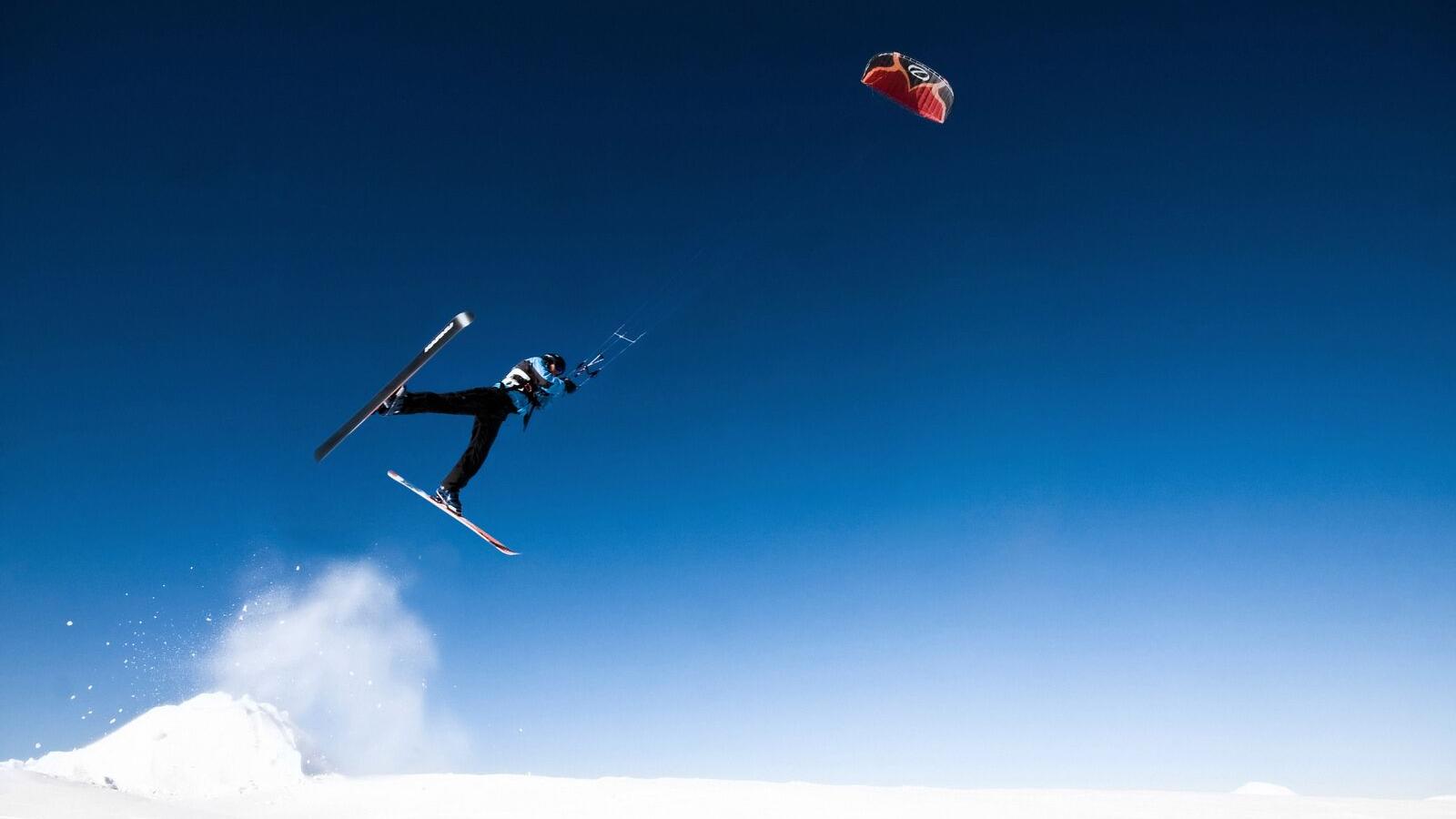 En person snøkiter under blå himmel i Narvik i Nord Norge
